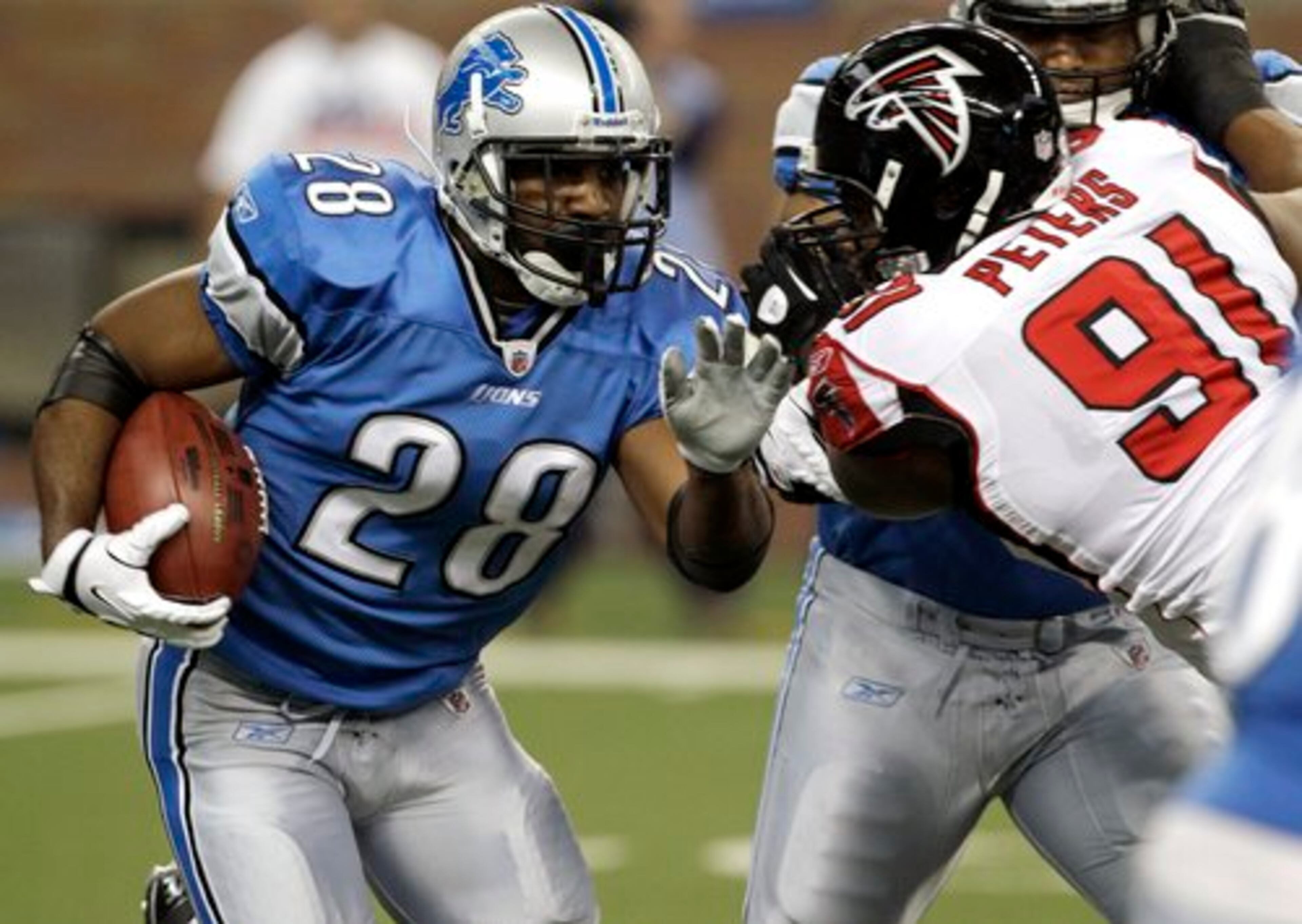 Falcons defensive lineman Corey Peters fights off a block while attempting to tackle Lions RB Maurice Morris.