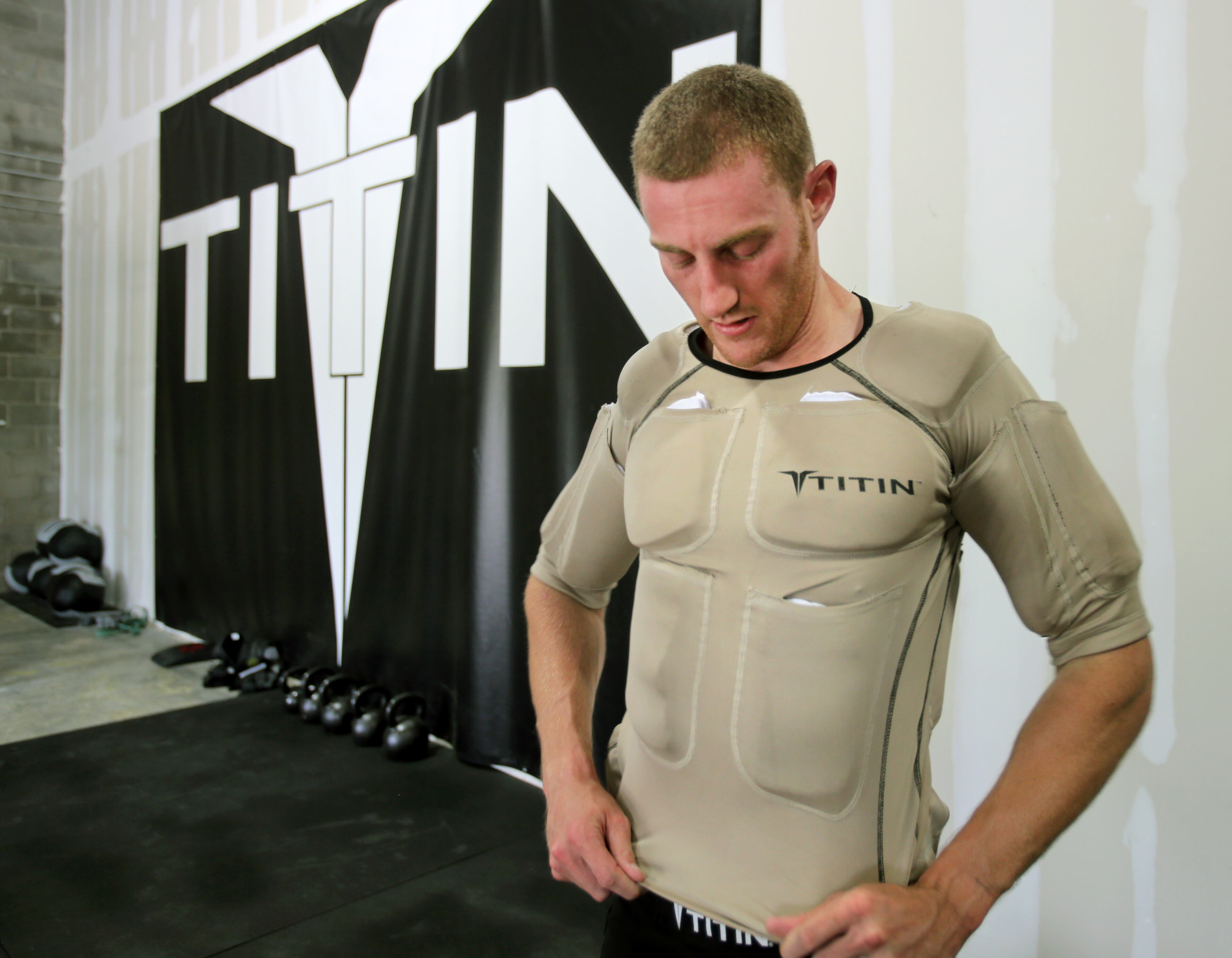 Patrick models a Titin shirt, which features 14 strategically placed pockets that contain 8 pounds of weighted gels across the upper body and upper arms. The shirt can be placed in the freezer to chill it before working out.