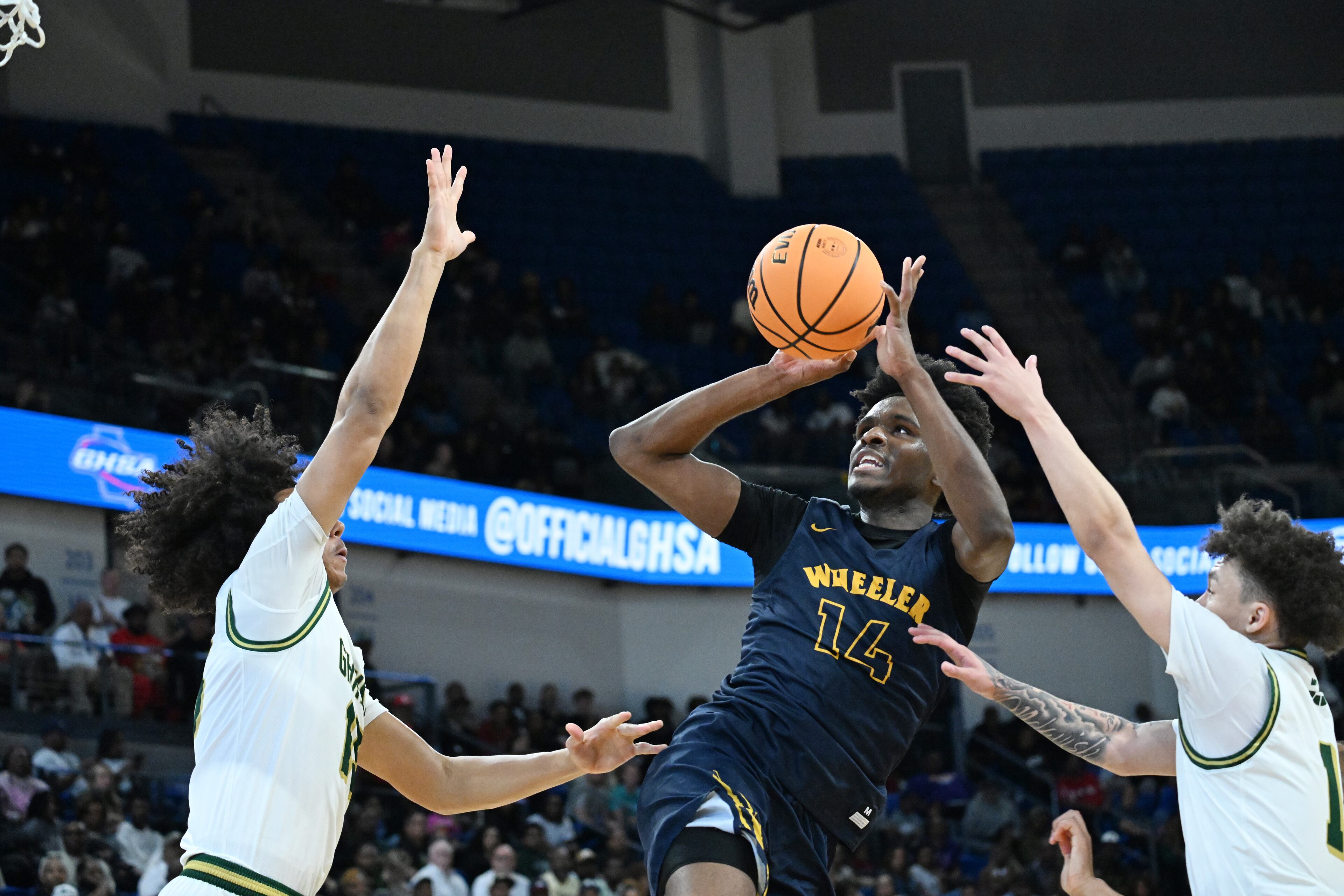Wheeler's Mansur Mcclain (14) gets off a shot against Grayson's Travis Burgess (left) during the second half of the GHSA Class 6A Boys State Basketball playoffs game at the Georgia State Convocation Center, Saturday, March 1, 2025, in Atlanta. Wheeler won 68-53 over Grayson. (Hyosub Shin / AJC)