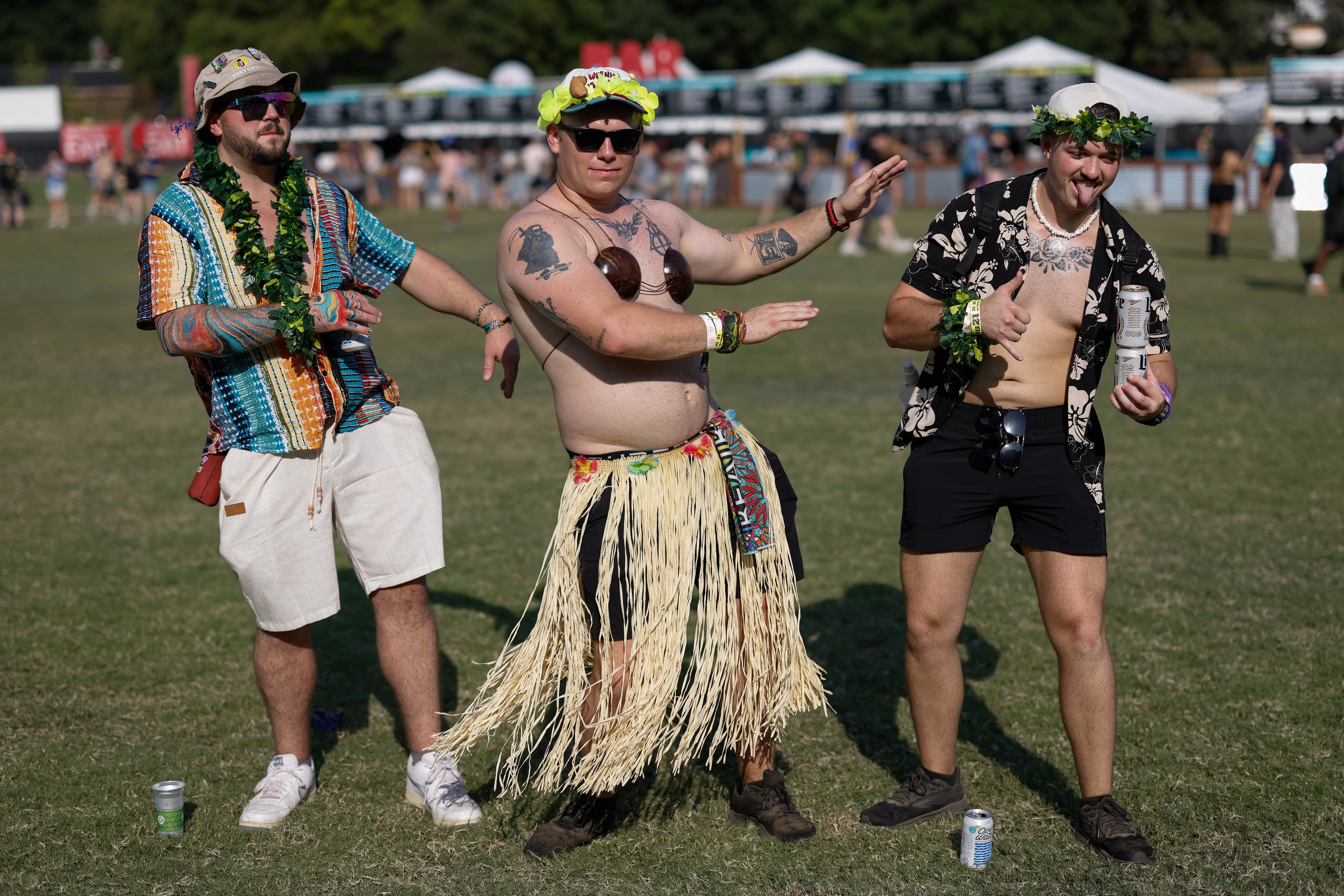 From left to right lIrving Christiansen, Luke Snider and Dylan Vaughan dance in Hawaiian garb during the Shaky Knees music festival at Piedmont Park, Saturday, Sept. 19, 2026, in Atlanta. (Erik S. Lesser for the AJC)