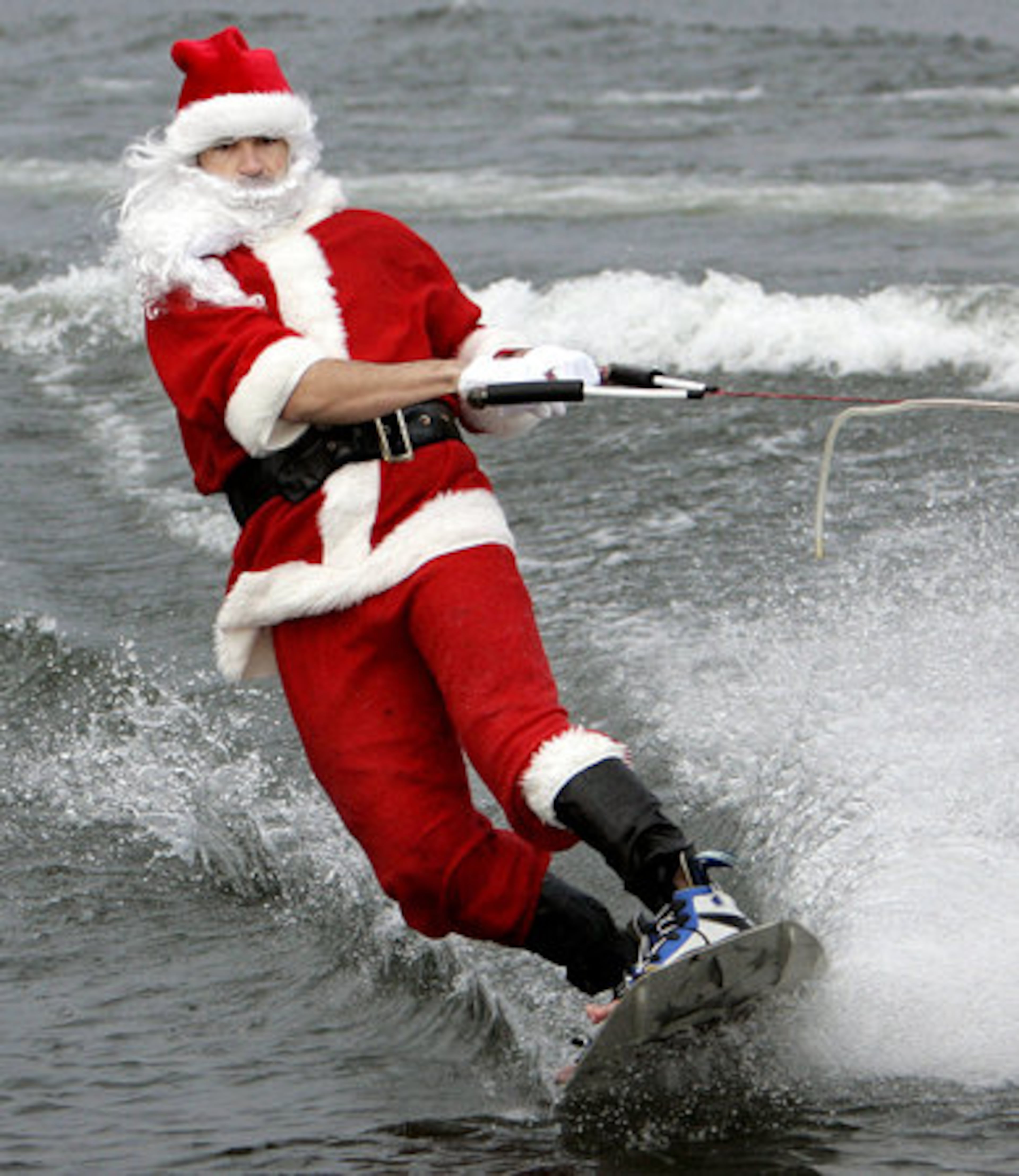 Mike Rolins water skis dressed as Santa near Six Mile Creek Park in Lake Lanier on Thursday, Dec. 24. Rolins and friends have carried on the tradition of skiing as Santa on Christmas eve for the past eight years. Rolins wore the full Santa suit, beard, hat, boots while wake boarding after a "dock starts" at the park.