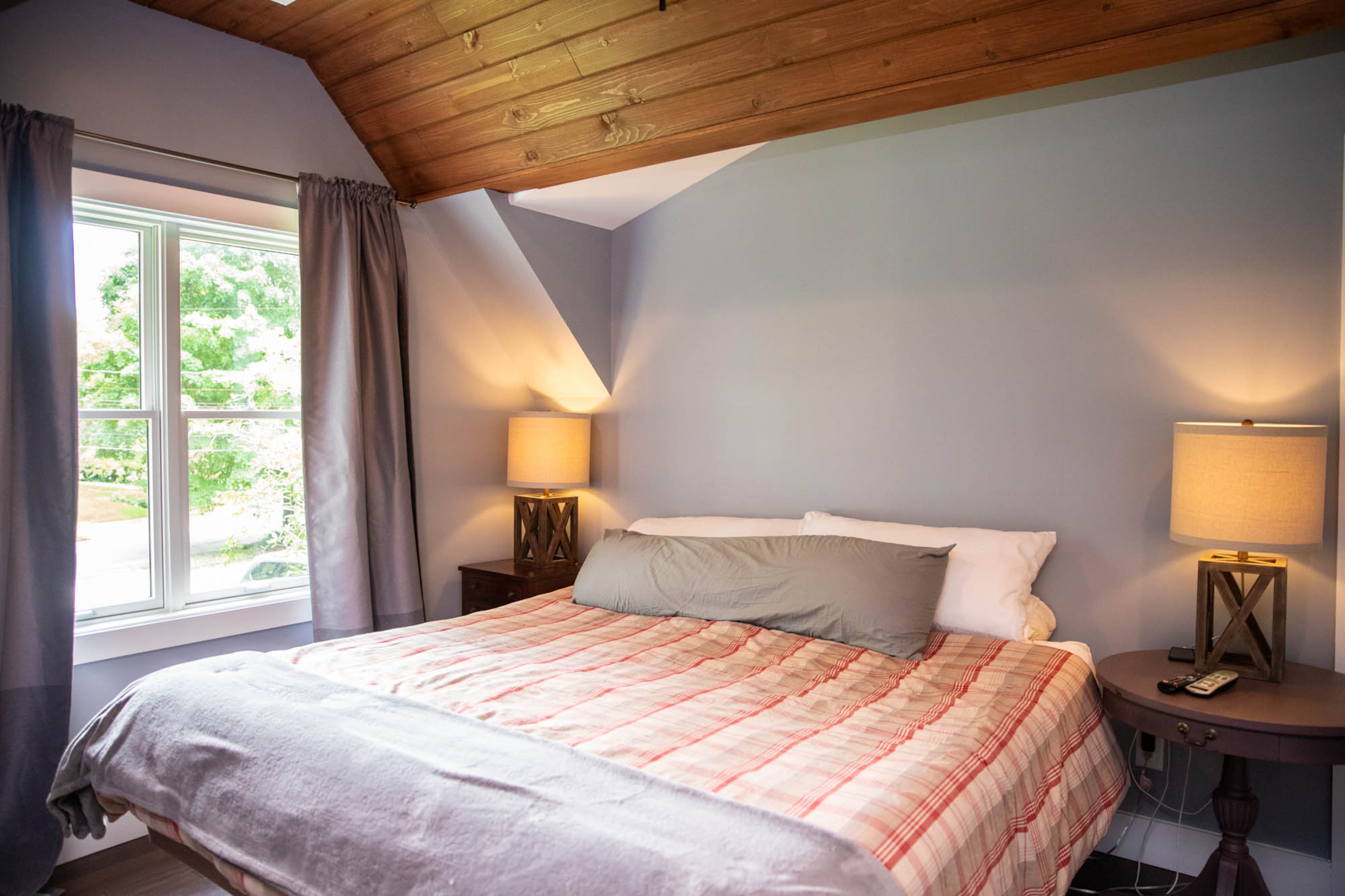 Walls painted Sherwin Williams Morning Fog create a soft background in Adam Perry and Ben Ratossa's master bedroom. An adjustable bed from Mattress Firm gives the space practical comfort, and keeping the space clutter free and simple gives it a visual clarity.
