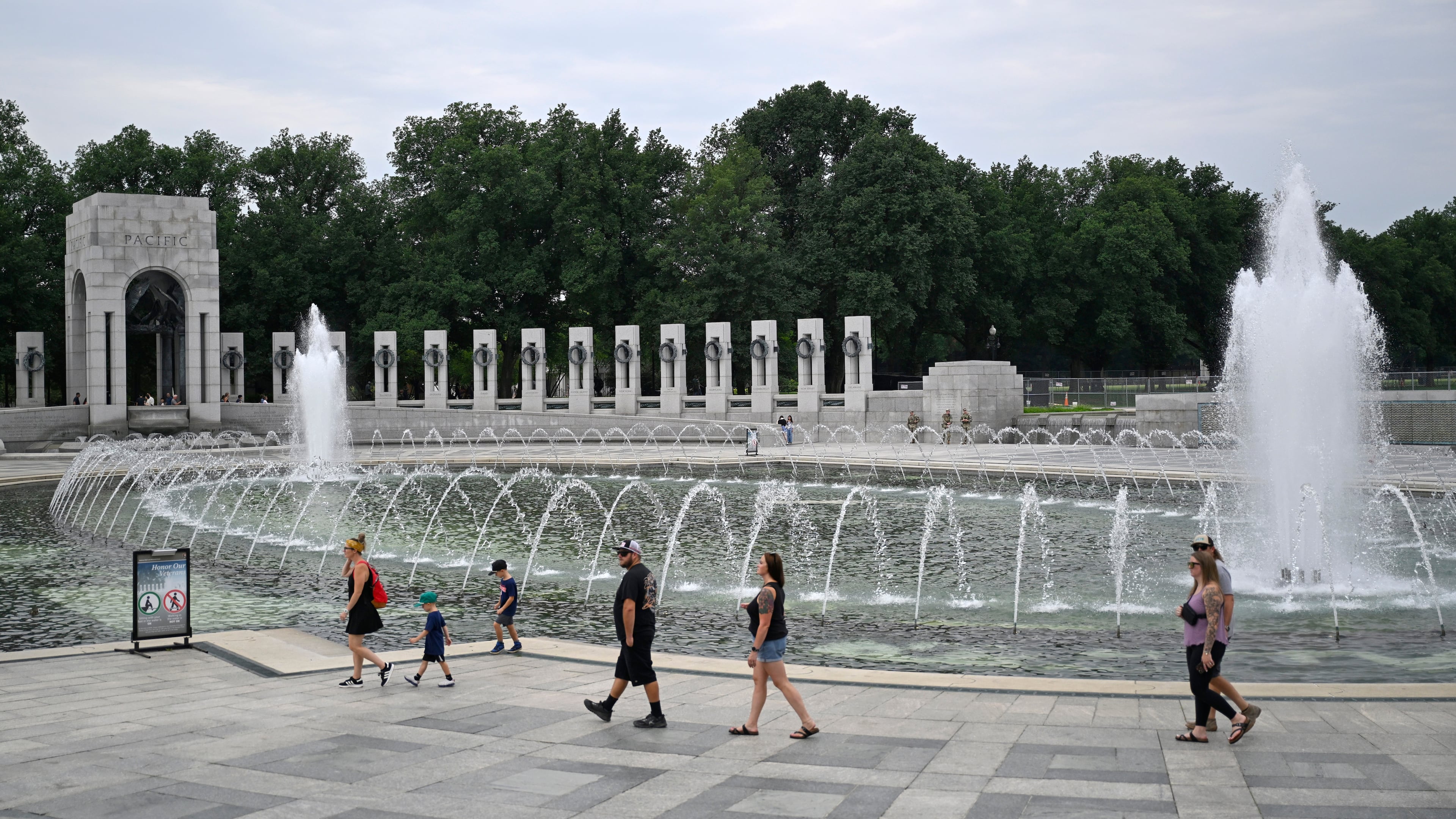 Visitors walk the WWII memorial the morning after it was vandalized, shown Friday, Aug. 14, 2026, in Washington. (AP Photo/John McDonnell)