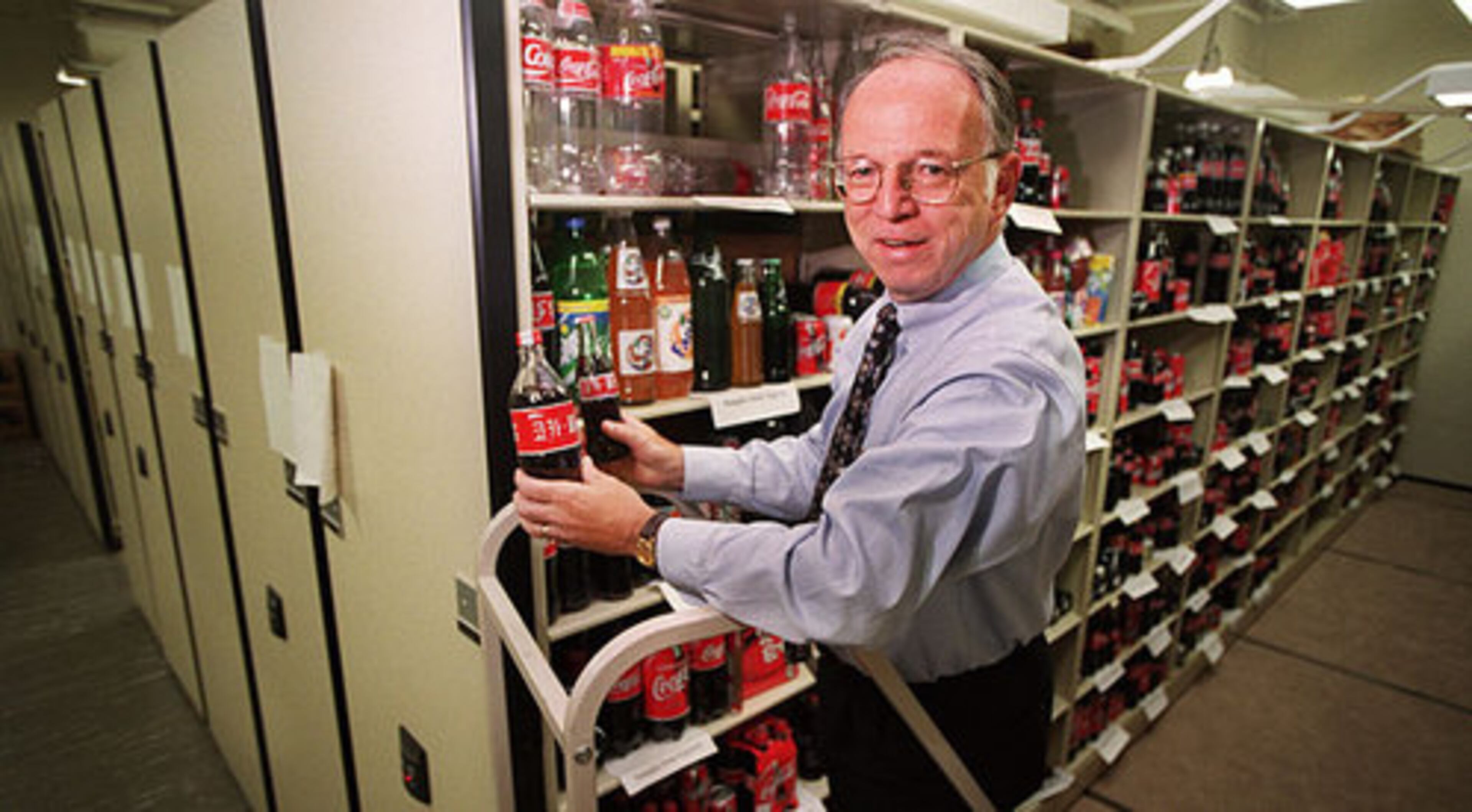 Coca-Cola archive department manager Philip Mooney retieves some bottles from one of the racks in the archive room.