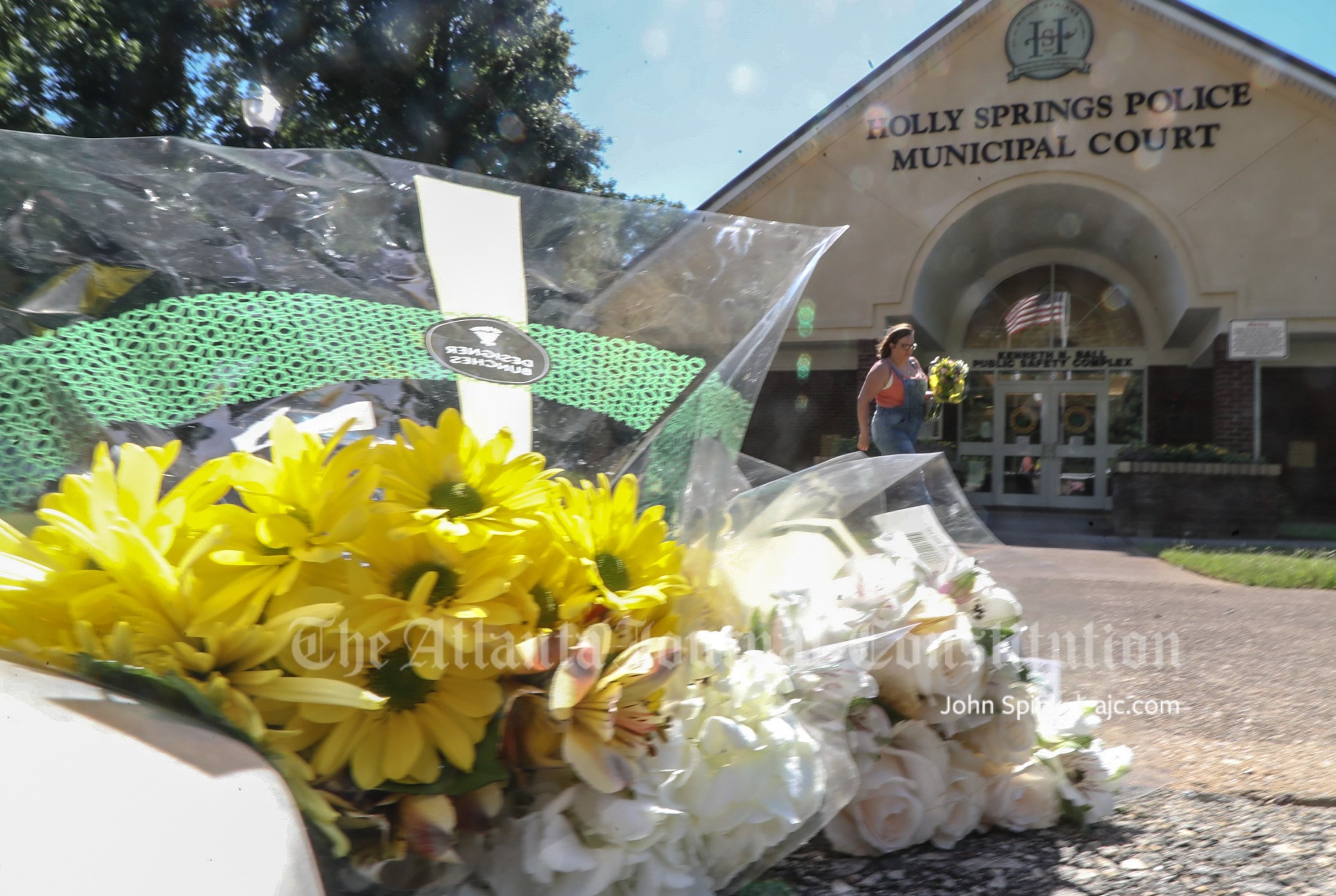Amber Miller lays flowers at the Holly Springs Police Department building the morning after an officer was killed during a traffic stop.
