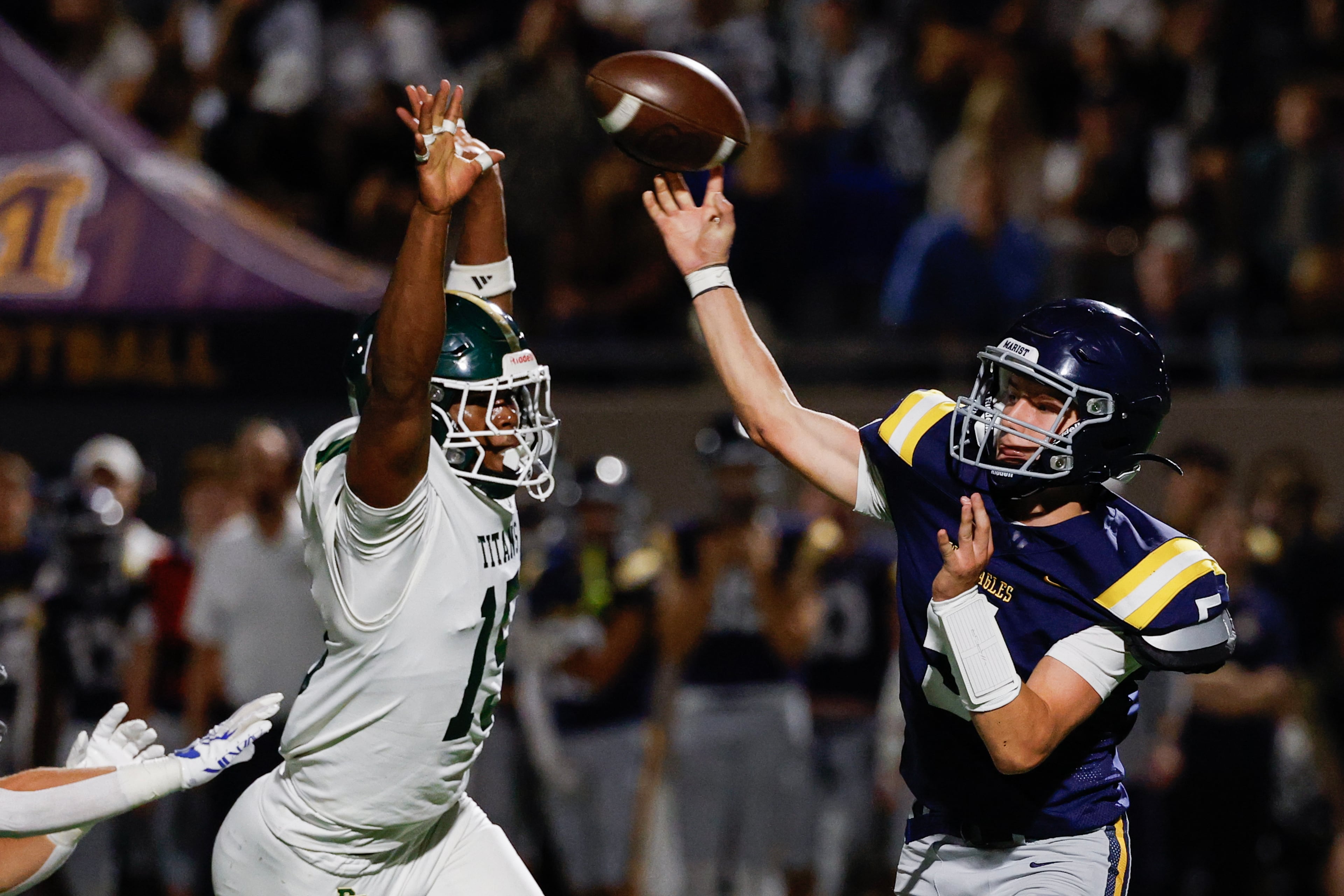 Marist quarterback Hayes Rollauer (right) passes under pressure from Blessed Trinity linebacker DJ Jacobs during their game on Friday, Sept. 25, 2026, in Atlanta. (Erik S. Lesser for the AJC)