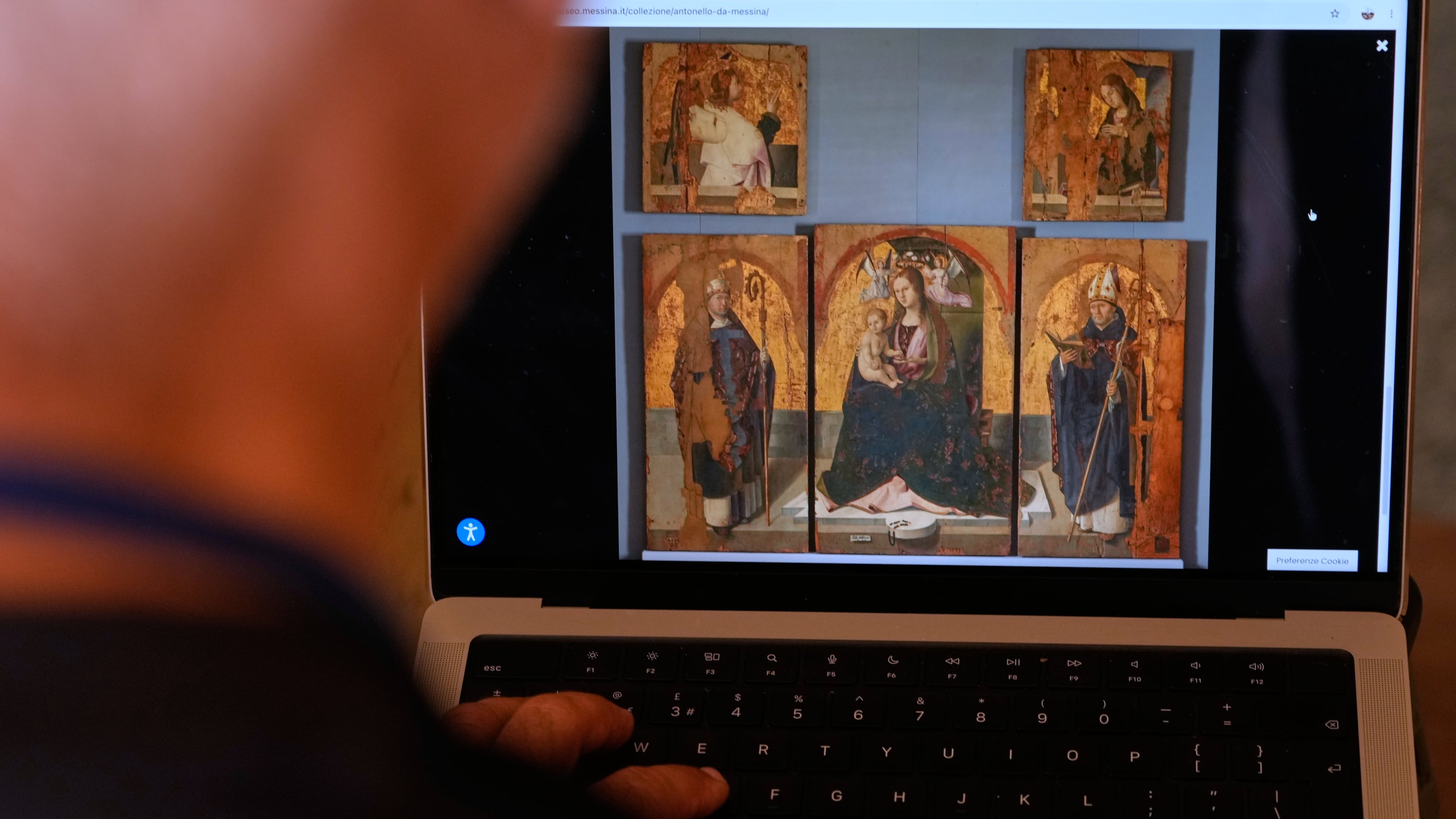 A journalist browses the Messina museum website showing a picture of the Early Renaissance painter Antonello da Messina's artwork where three of the five panels belonging to the Polyptych of San Gregorio and the double-sided panel with the Madonna and the Christ in Pietà, stolen from the Sicilian museum on Aug. 15, in Rome, Sunday, Aug. 16, 2026. (AP Photo/Gregorio Borgia)