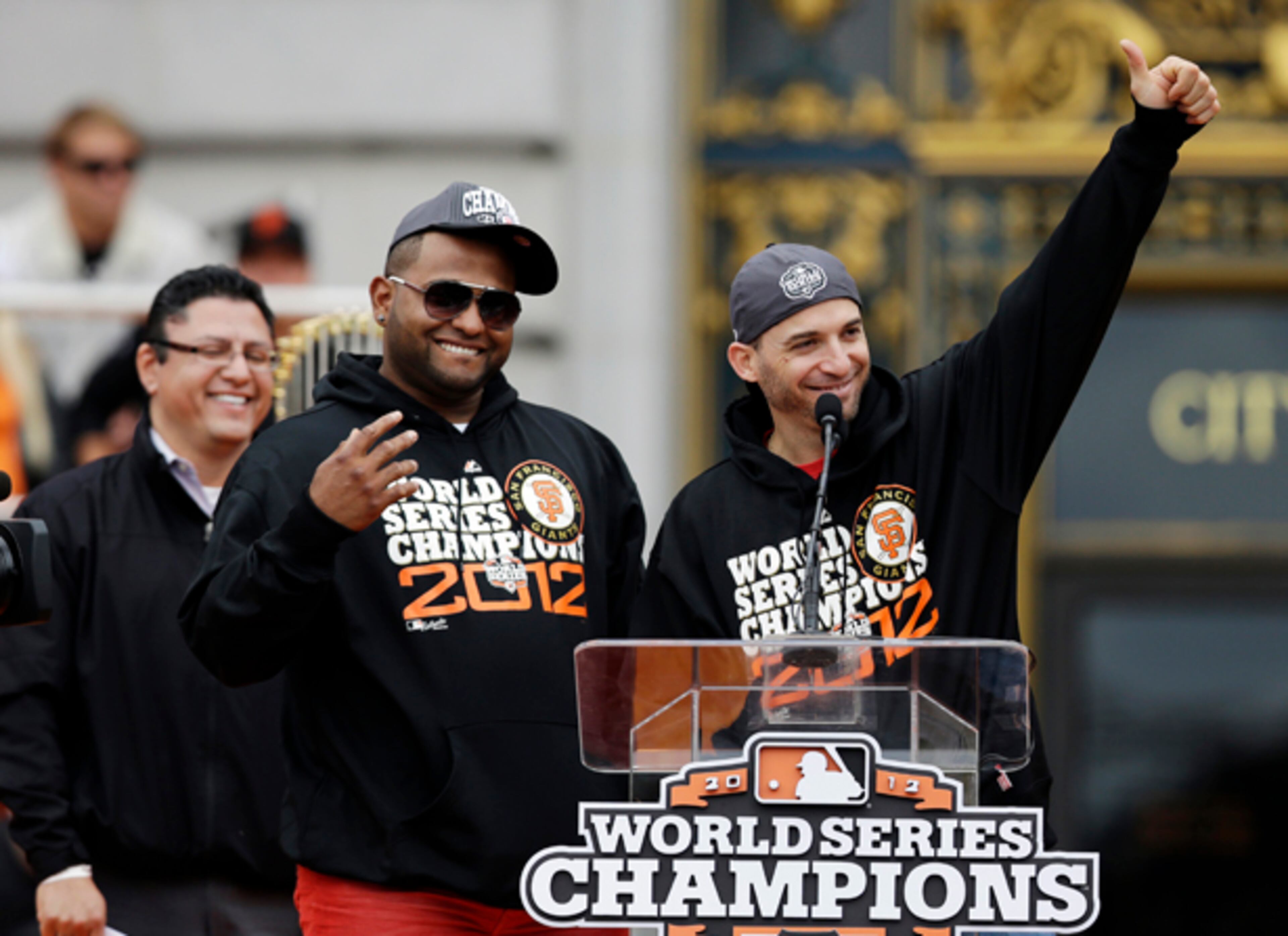 San Francisco Giants third baseman Pablo Sandoval, left, and second baseman Marco Scutaro, right, of Venezuela, smile while standing at the podium during the baseball team's World Series victory celebration at City Hall Wednesday, Oct. 31, 2012, in San Francisco. Sandoval was the World Series MVP and Scutaro was the MVP of the National League Championship Series. The team's second championship in three years included a parade along Market Street and ended with a celebration in front of City Hall. (AP Photo/Marcio J. Sanchez)