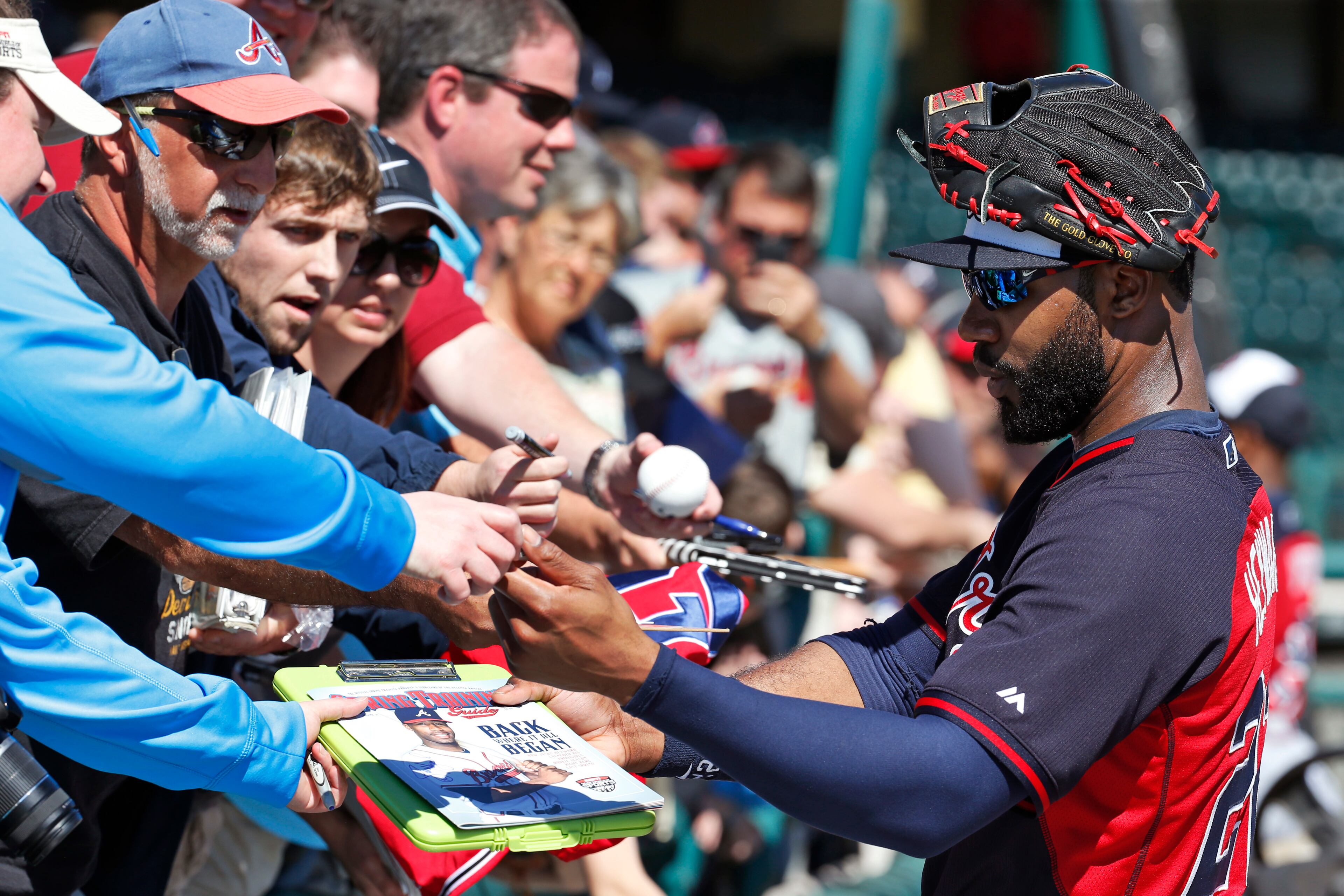 Atlanta Braves right fielder Jason Heyward signs autographs for fans during a spring training baseball workout, Sunday, Feb. 16, 2014, in Kissimmee, Fla. (AP Photo/Alex Brandon)