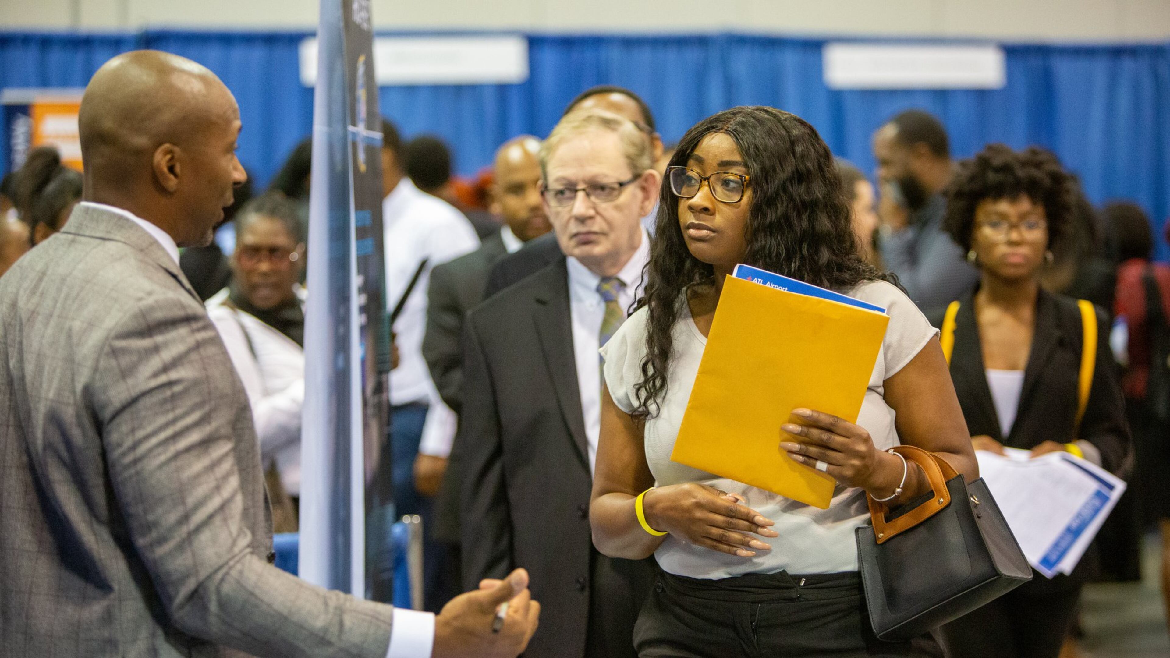 Job growth in metro Atlanta has been substantial, so finding a job is much easier than a few years ago. But finding one that pays well is harder. Here, FBI Special Agent, recruiter Charles Orgbon Jr (left) talks with Desiree Harvey-Lovell during a recent job fair at the Georgia International Convention Center. (Photo by Phil Skinner)