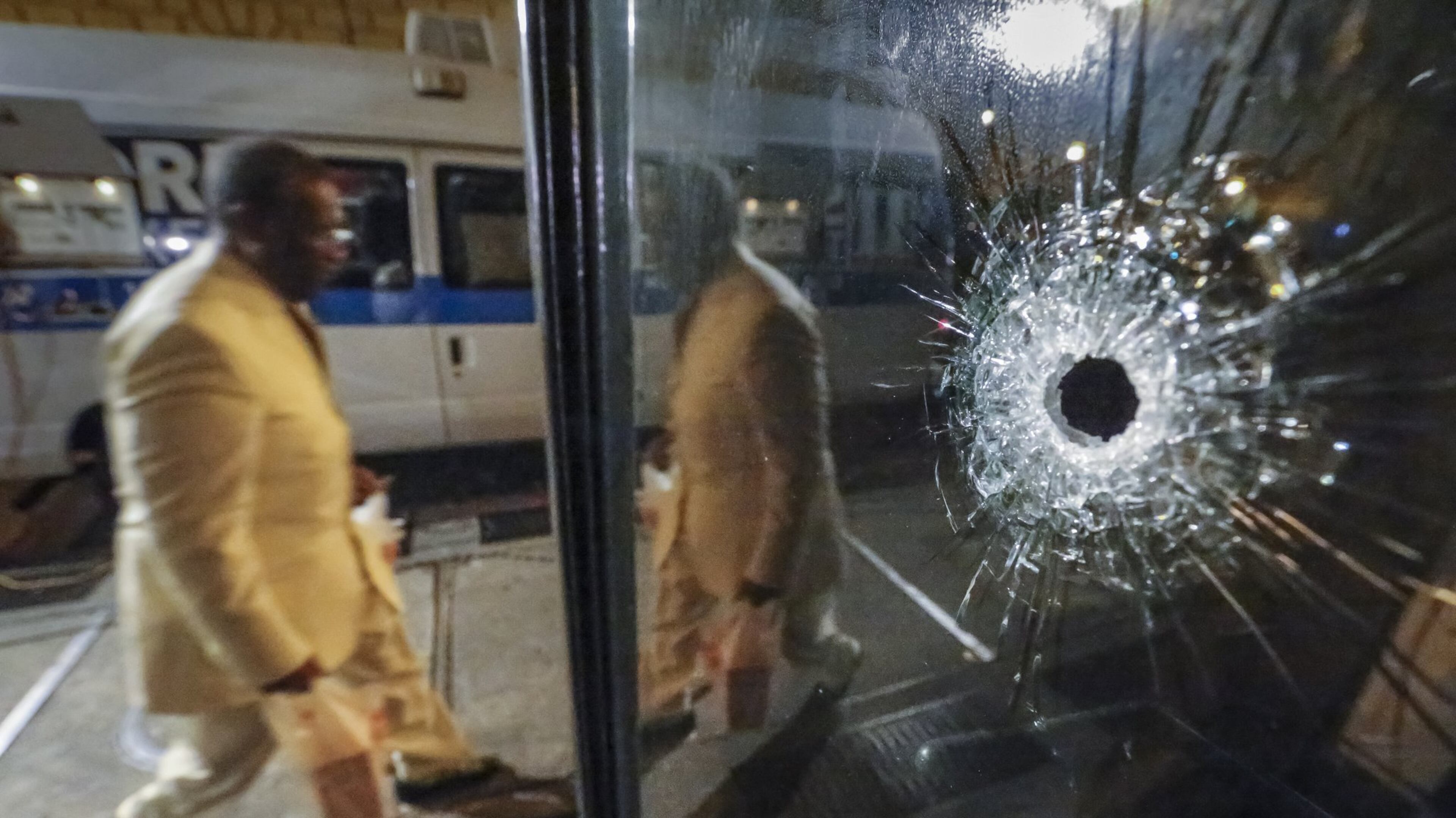 A pedestrian walks by the bullet hole and boarded up business at the scene of a quadruple shooting on Forsyth Street in downtown Atlanta on Thursday morning, Feb. 25, 2016. JOHN SPINK / JSPINK@AJC.COM
