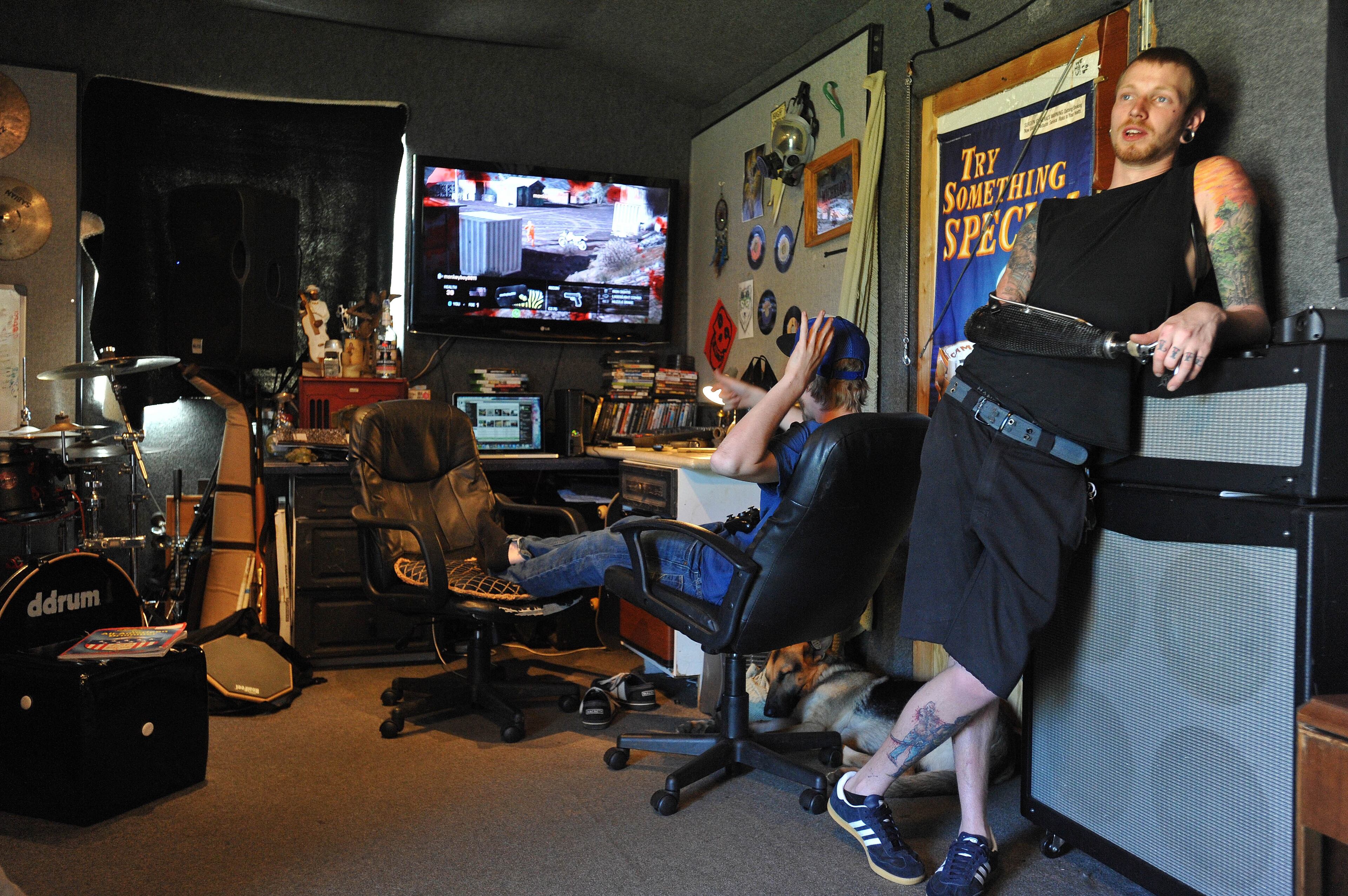 Jason Barnes, a drummer who lost his right hand in an accident, relaxes in his music room with as his friend Andrew Thomason plays video games on Tuesday April 1, 2014 in Locust Grove, Ga. David Tulis / AJC Special