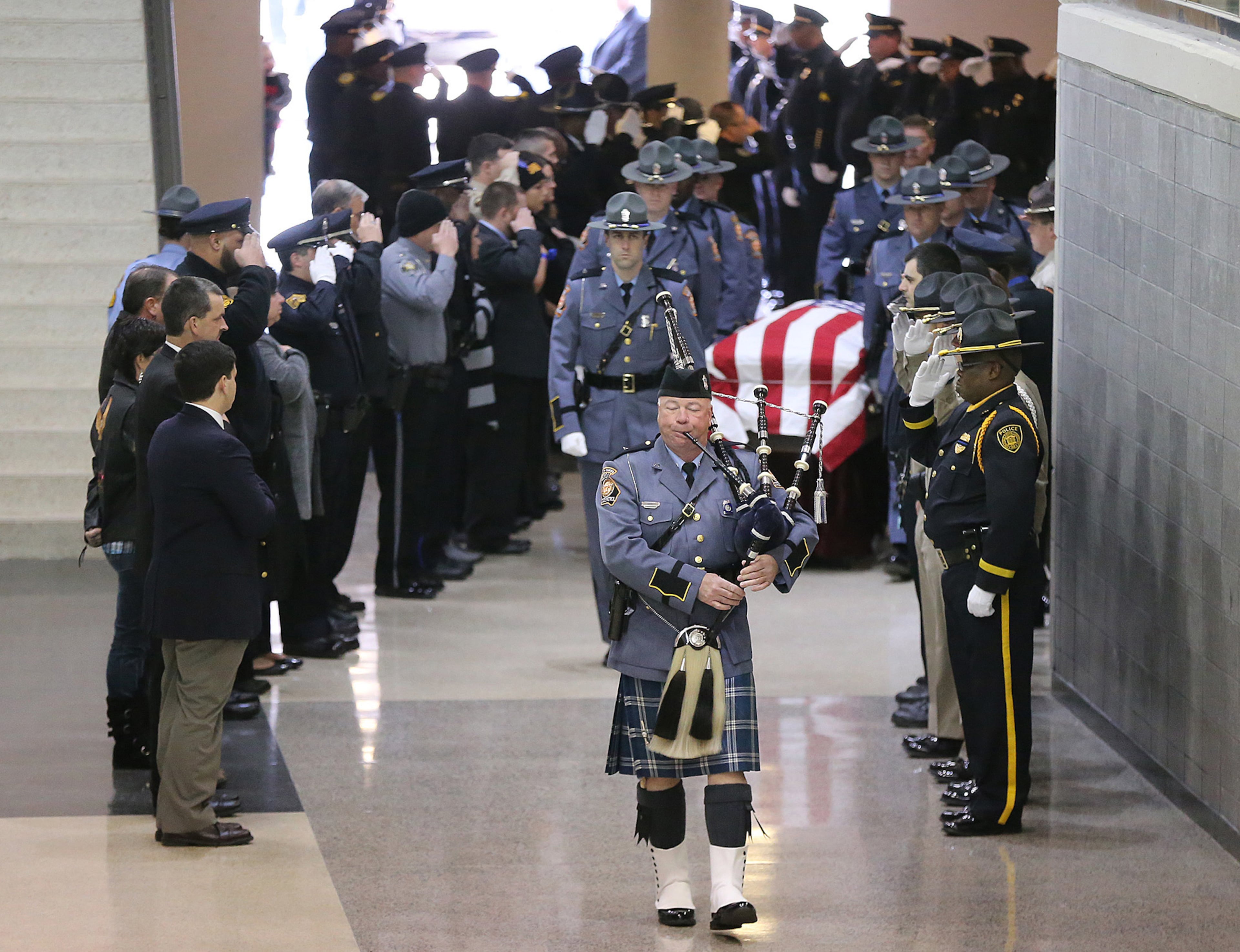 December 11, 2016, AMERICAS: Americus police officers salute their fellow Americus police officer Nicholas Ryan Smarr with bagpipes leading his honor guard to his funeral service at the Georgia Southwestern State University Storm Dome on Sunday, Dec. 11, 2016, in Americas. Officer Smarr and Georgia Southwestern State University campus police officer Jody Smith were killed responding to a domestic dispute. Curtis Compton/ccompton@ajc.com