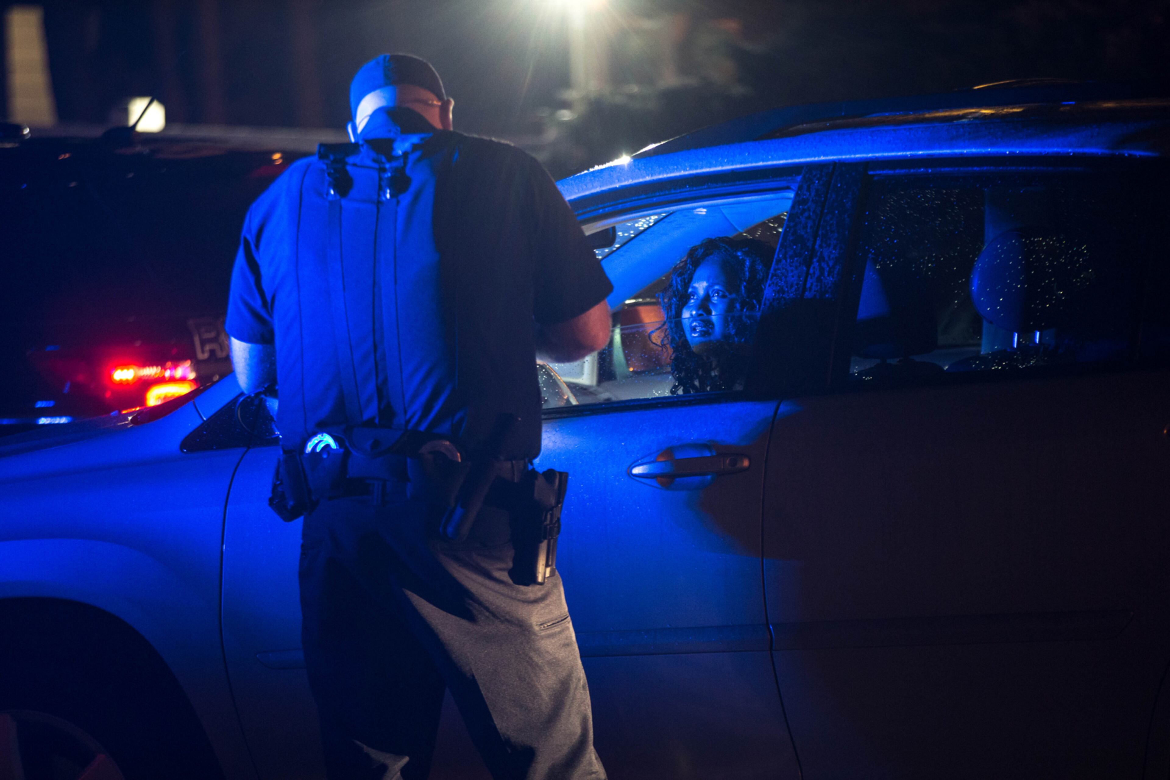 A Roswell Police officer talks to a resident at Nesbit Ferry Crossing Apartments where a 17-year-old boy was shot and killed, Tuesday, Feb. 7, 2017, in Roswell, Ga. BRANDEN CAMP/SPECIAL