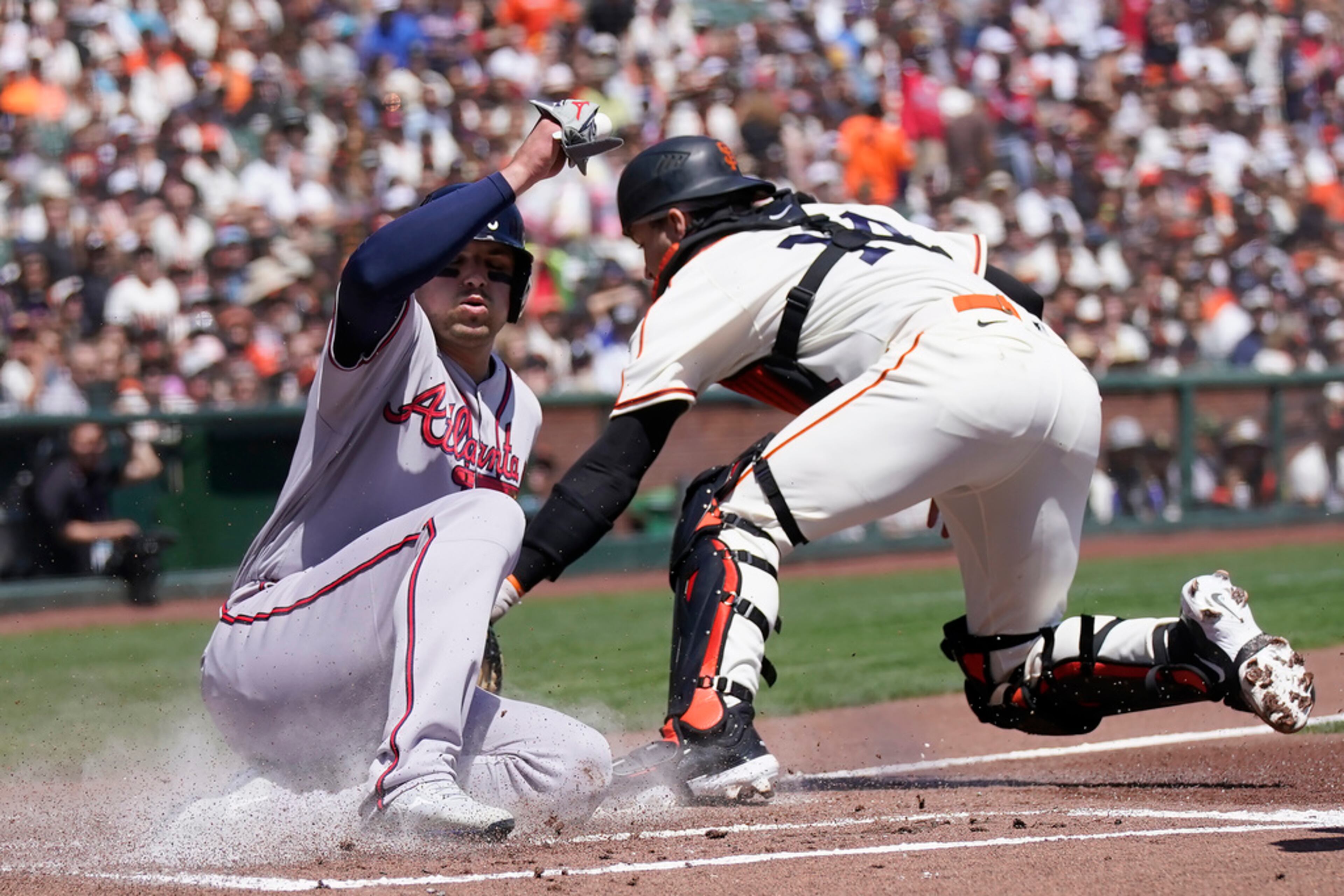 Atlanta Braves' Austin Riley, left, scores against San Francisco Giants catcher Patrick Bailey during the first inning of a baseball game in San Francisco, Saturday, Aug. 26, 2023. (AP Photo/Jeff Chiu)