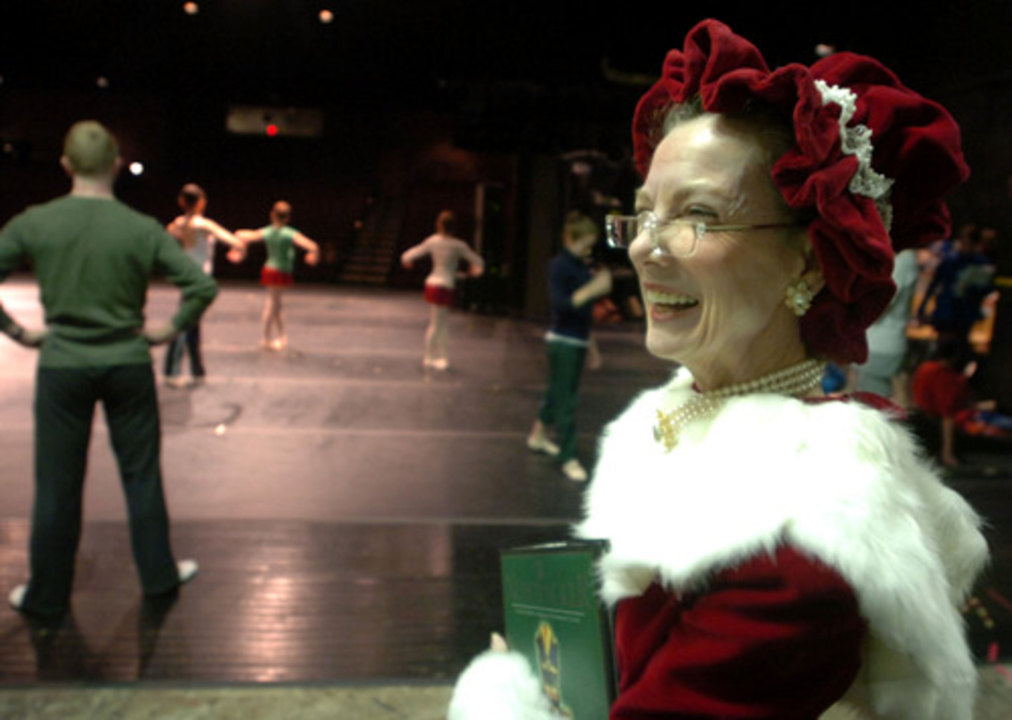 Barbara Hancock-Elrod, playing the role of Mrs. Santa Claus, waits to go on stage about 45 minutes before the performance. Dancers can be seen limbering up in the background.