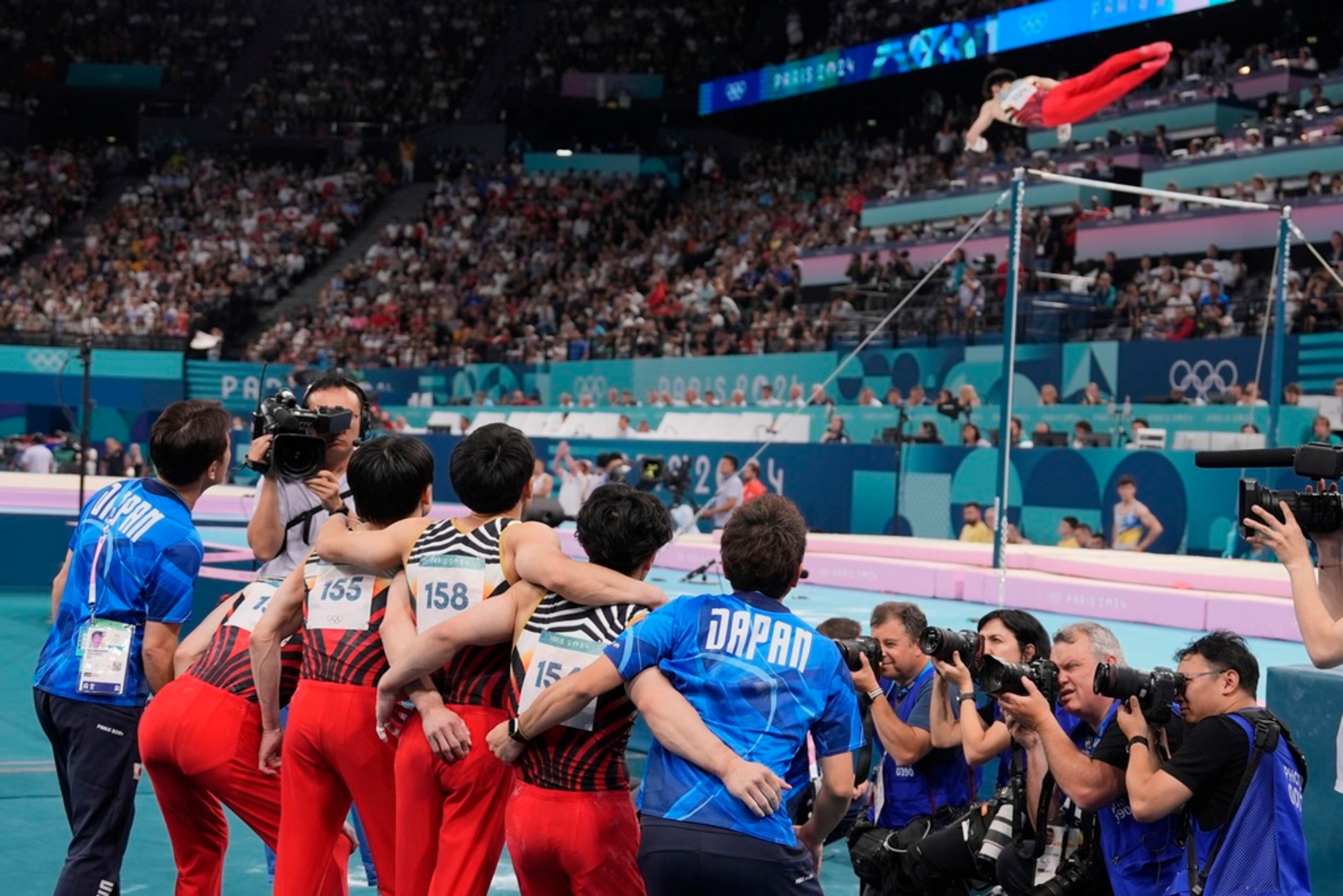 Team Japan watch together as Daiki Hashimoto, performs on the high bar in the final rotation during the men's artistic gymnastics team finals round at Bercy Arena at the 2024 Summer Olympics, Monday, July 29, 2024, in Paris, France. (AP Photo/Charlie Riedel)