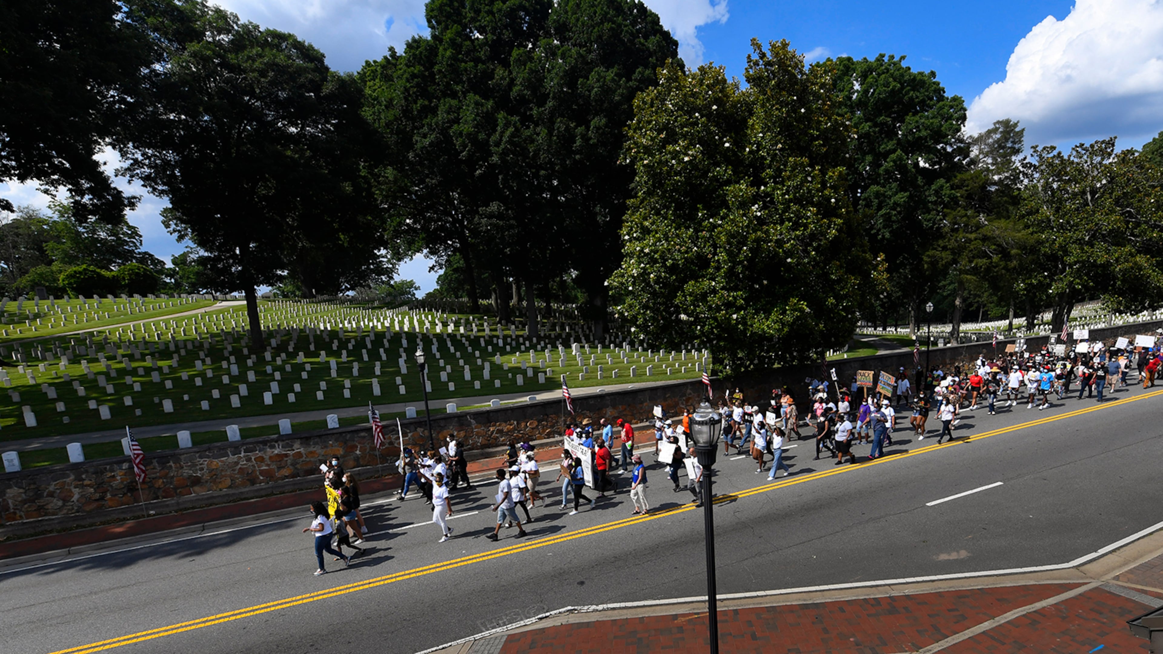 Marchers make their way past the National Park Services civil war cemetery from the Cobb NAACP offices to Marietta Square during a demonstration to commemorate Juneteenth on Friday June 19, 2020, in Marietta. JOHN AMIS FOR THE ATLANTA JOURNAL-CONSTITUTION