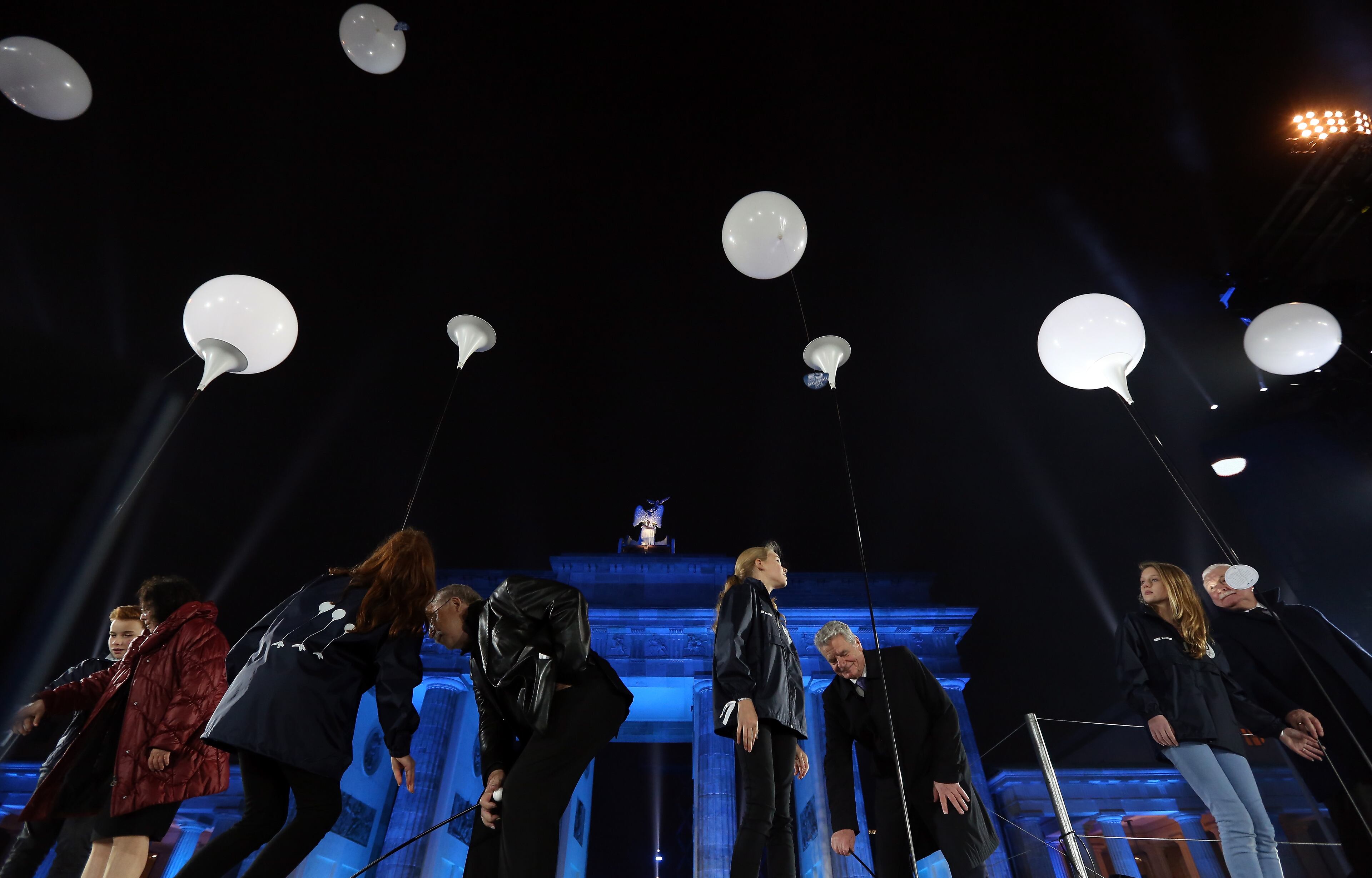 German President Joachim Gauck (C R), German singer-songwriter and former East German dissident Wolf Biermann (C L) and Polish Solidarity (Solidarnosc) Leader Lech Walesa (R) launch balloons from the Lichtgrenze light installation during celebrations for the 25th anniversary of the fall of the Berlin Wall at the Brandenburg Gate on November 9, 2014 in Berlin, Germany. The city of Berlin is commemorating the 25th anniversary of the fall of the Berlin Wall from November 7-9 with an installation of 6,800 lamps coupled with illuminated balloons along a 15km route where the Wall once ran and divided the city into capitalist West and communist East. The fall of the Wall on November 9, 1989, was among the most powerful symbols of the revolutions that swept through the communist countries of Eastern Europe and heralded the end of the Cold War. Built by the communist authorities of East Germany in 1961, the Wall prevented East Germans from fleeing west and was equipped with guard towers and deadly traps. (Photo by Adam Berry/Getty Images)