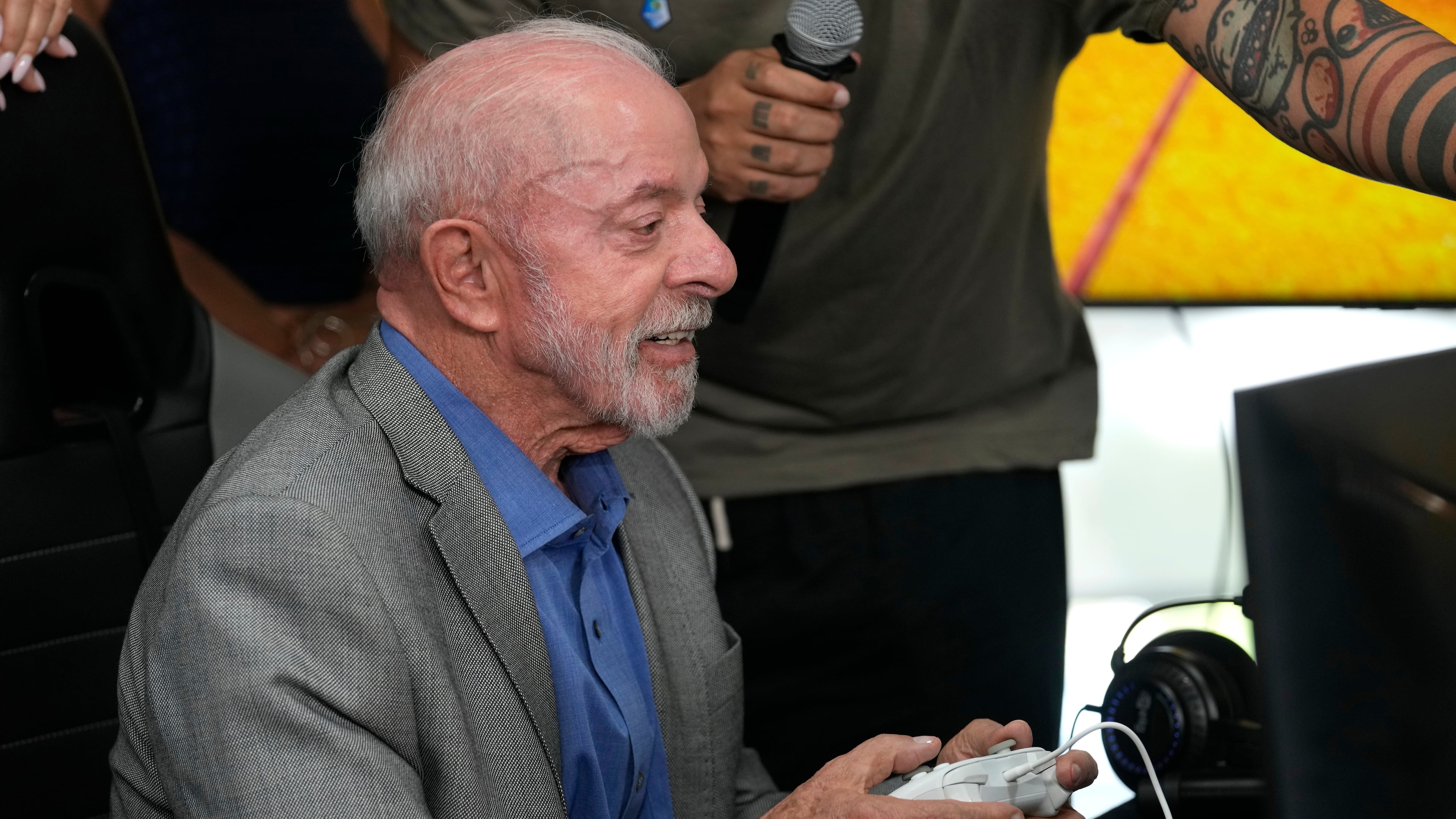 Brazilian President Luiz Inacio Lula da Silva, who is running for reelection, plays a Brazilian video game before a ceremony to sign a decree regulating the video game industry in Brasilia, Brazil, Wednesday, Oct. 14, 2026. (AP Photo/Eraldo Peres)
