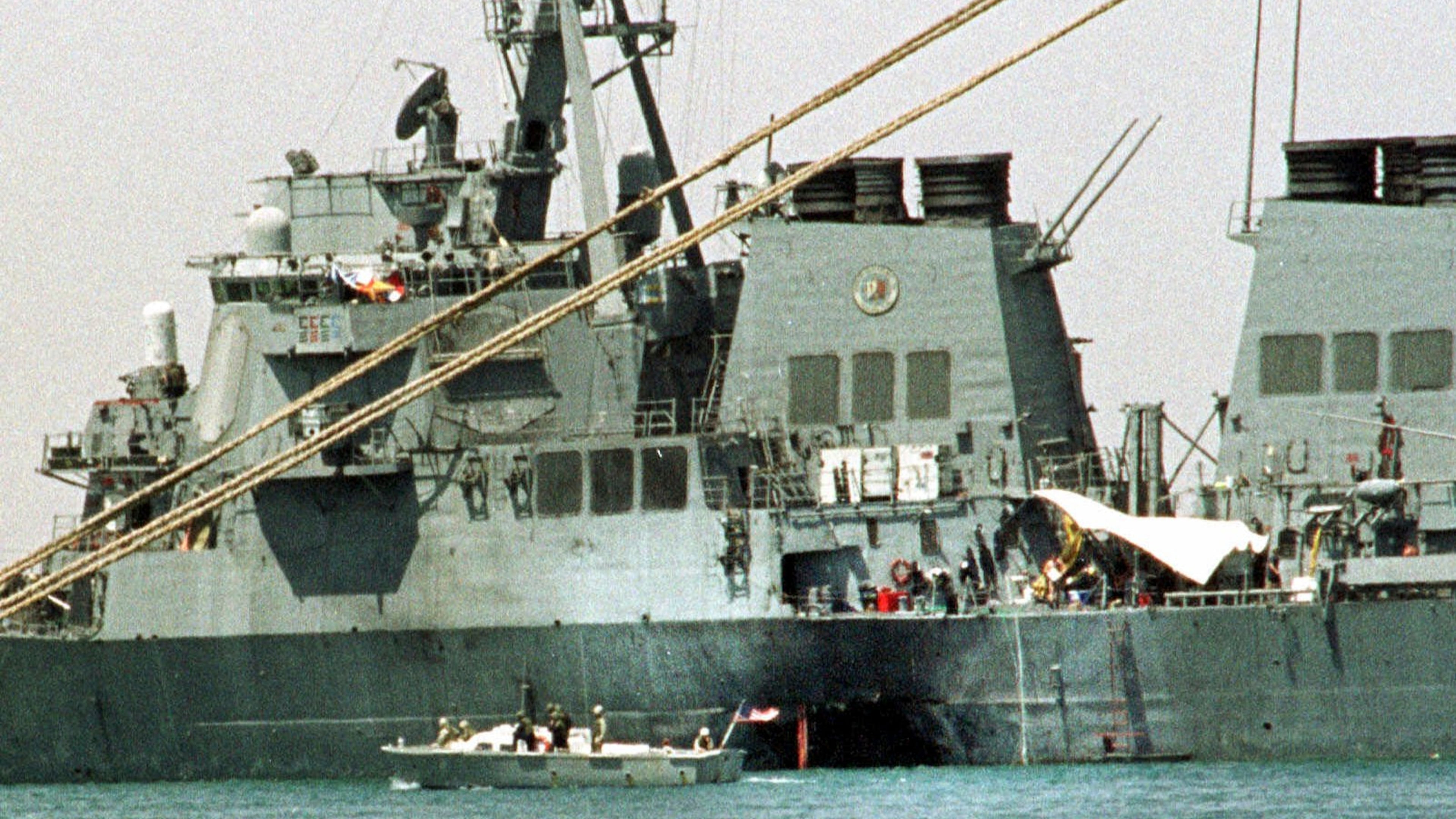 FILE - A small boat guards the stricken USS Cole in Aden, Yemen, Oct. 20, 2000. (AP Photo/Hasan Jamali, File)