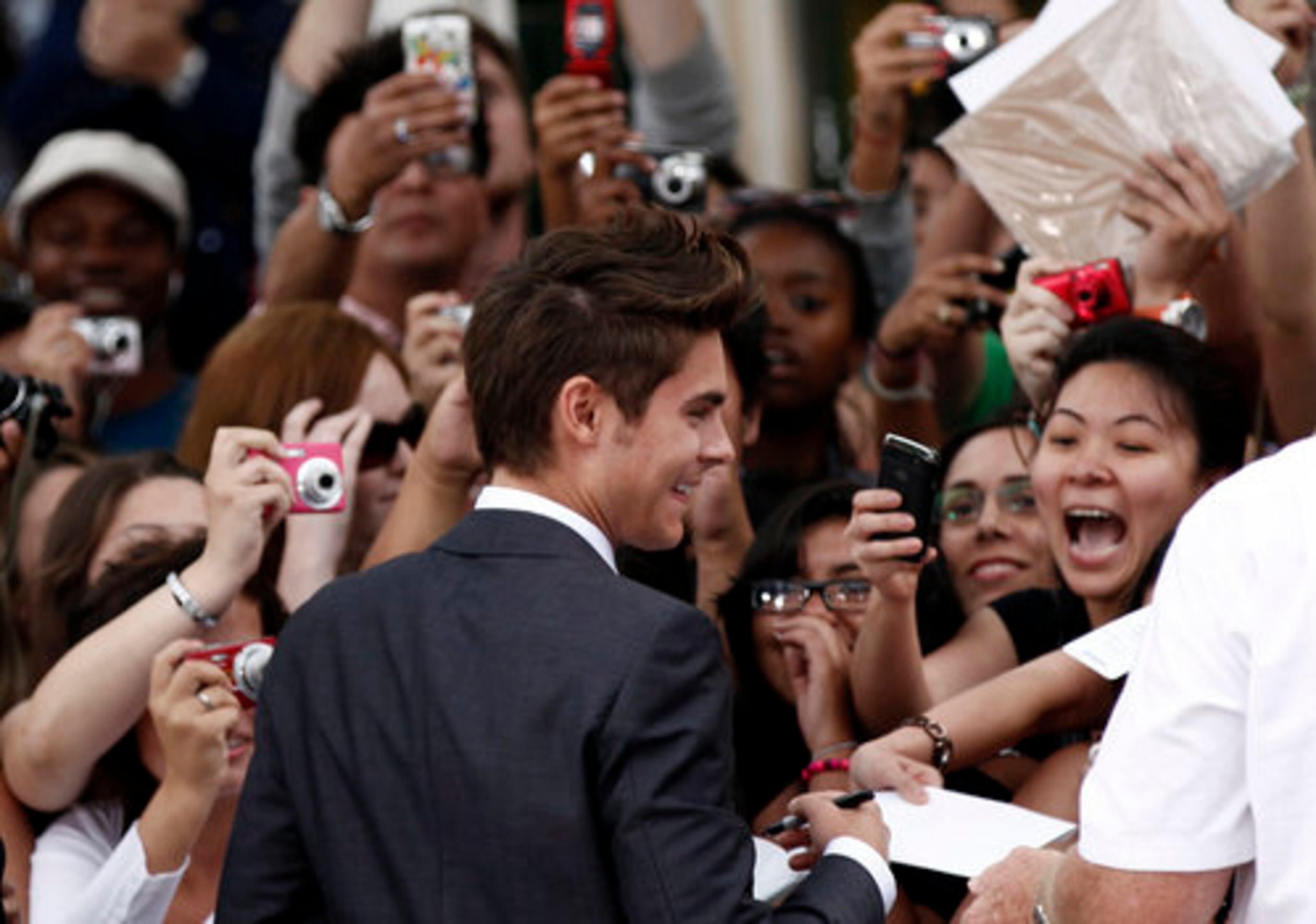 Cast member Zac Efron signs autographs for fans at the premiere of "Charlie St. Cloud" in Los Angeles, Tuesday, July 20, 2010.
