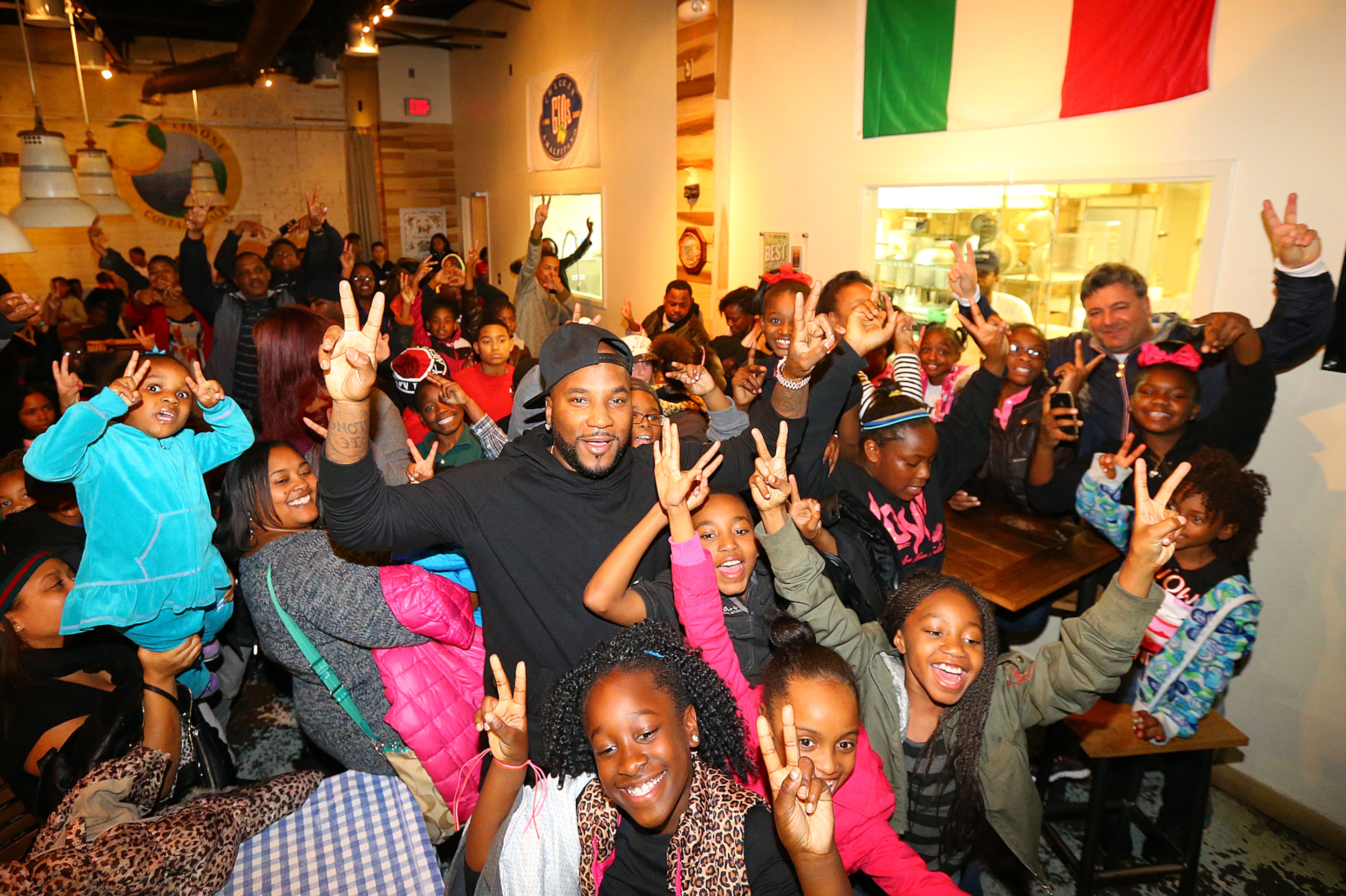 Jeezy (center), aka Jay Jenkins, and his foundation Street Dreams Foundation, host 200 needy inner city kids from Macon, Hawkinsville, and Atlanta for Christmas on Monday, Dec. 22, 2014, in Atlanta. The children were treated to a private screening of the movie Annie, followed by food and toys given out by "Santa Jeezy" at Gio's. Jeezy gathers the kids for a group photo after their pizza. Curtis Compton / ccompton@ajc.com