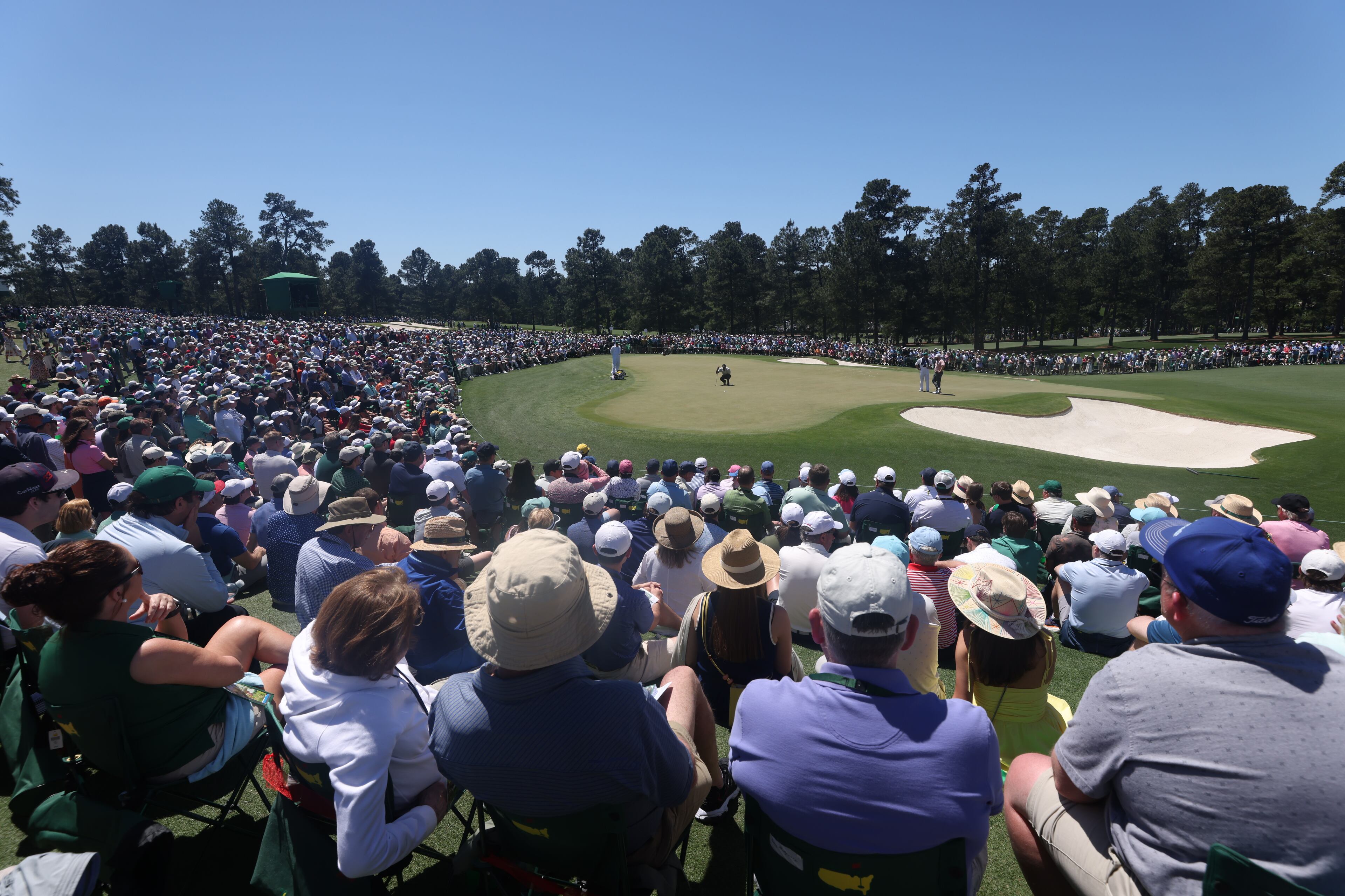 Patrons watch as Tiger Woods lines up putt on second hole during third round at the 2024 Masters Tournament at Augusta National Golf Club, Saturday, April 13, 2024, in Augusta, Ga. Jason Getz / Jason.Getz@ajc.com)