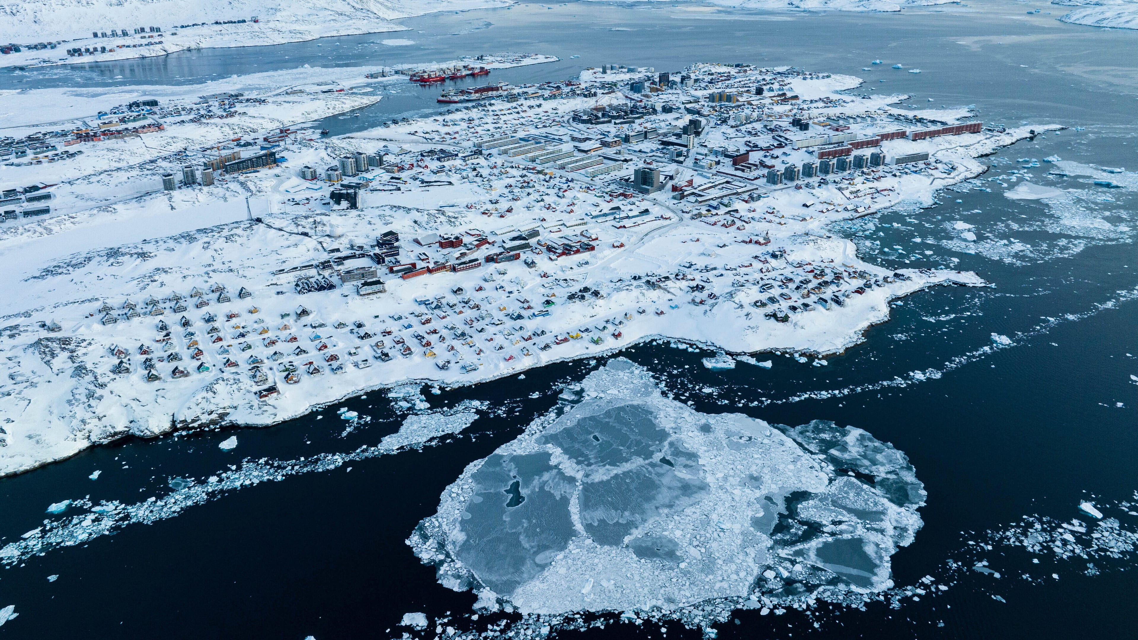 FILE - Houses covered by snow are seen on the coast of a sea inlet of Nuuk, Greenland, on March 7, 2025. (AP Photo/Evgeniy Maloletka, File)