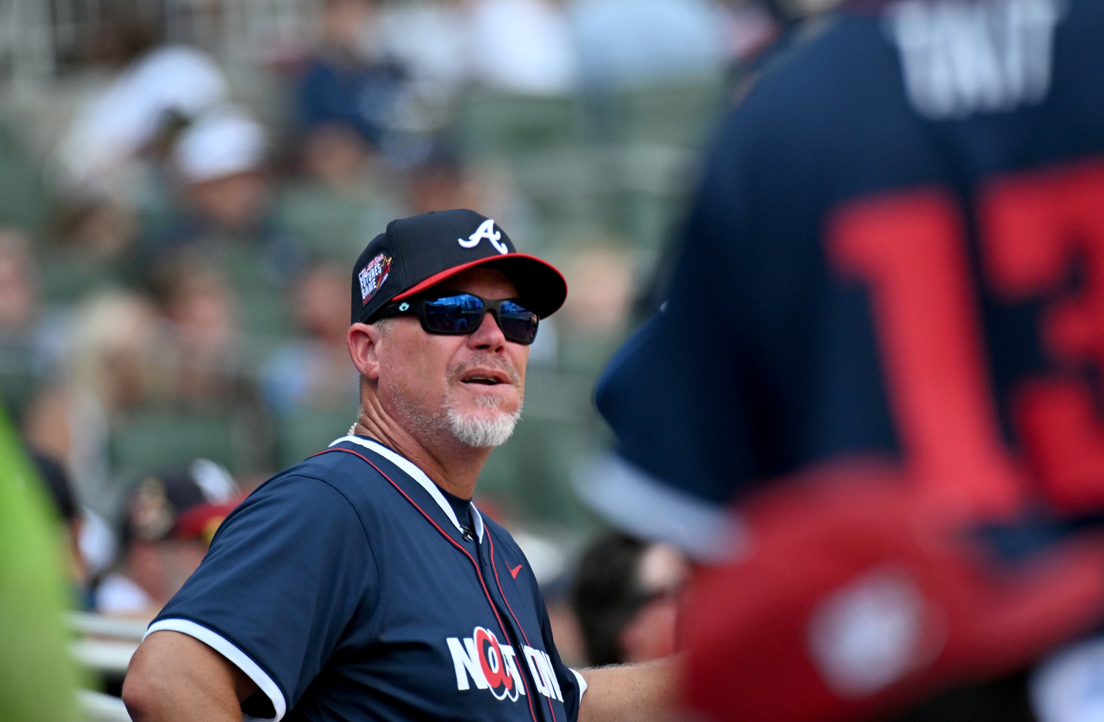 National League manager Chipper Jones watches from the dugout during the All-Star Futures Game at Truist Park, Saturday, July 12, 2025, in Atlanta. National League won 4-2 over American League. (Hyosub Shin / AJC)