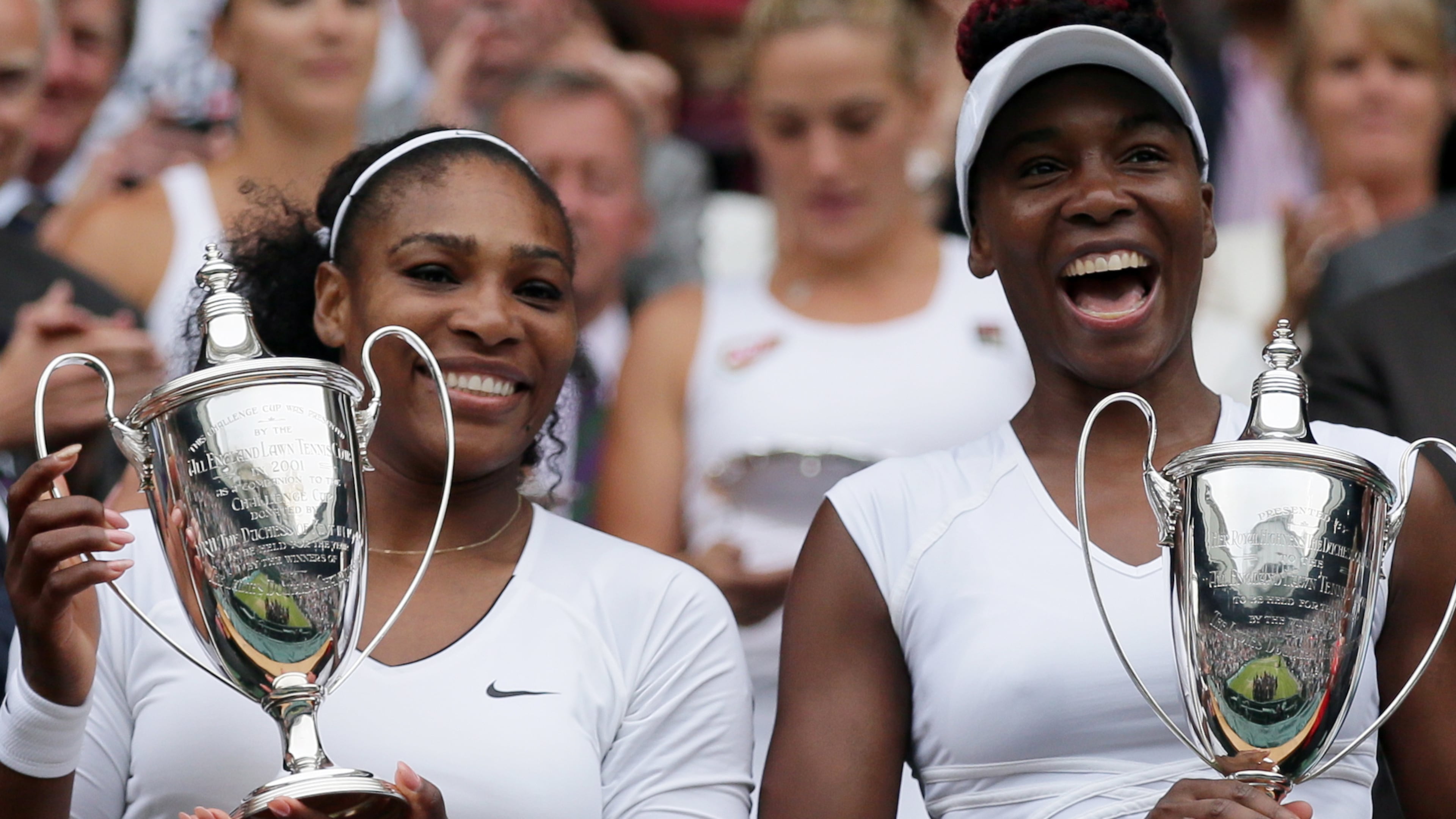 FILE -Serena Williams, left, and Venus Williams of the U.S hold their trophies after winning the women's doubles final against Yaroslava Shvedova of Kazahkstan and Timea Babos of Hungary on day thirteen of the Wimbledon Tennis Championships in London, July 9, 2016. (AP Photo/Tim Ireland, File)