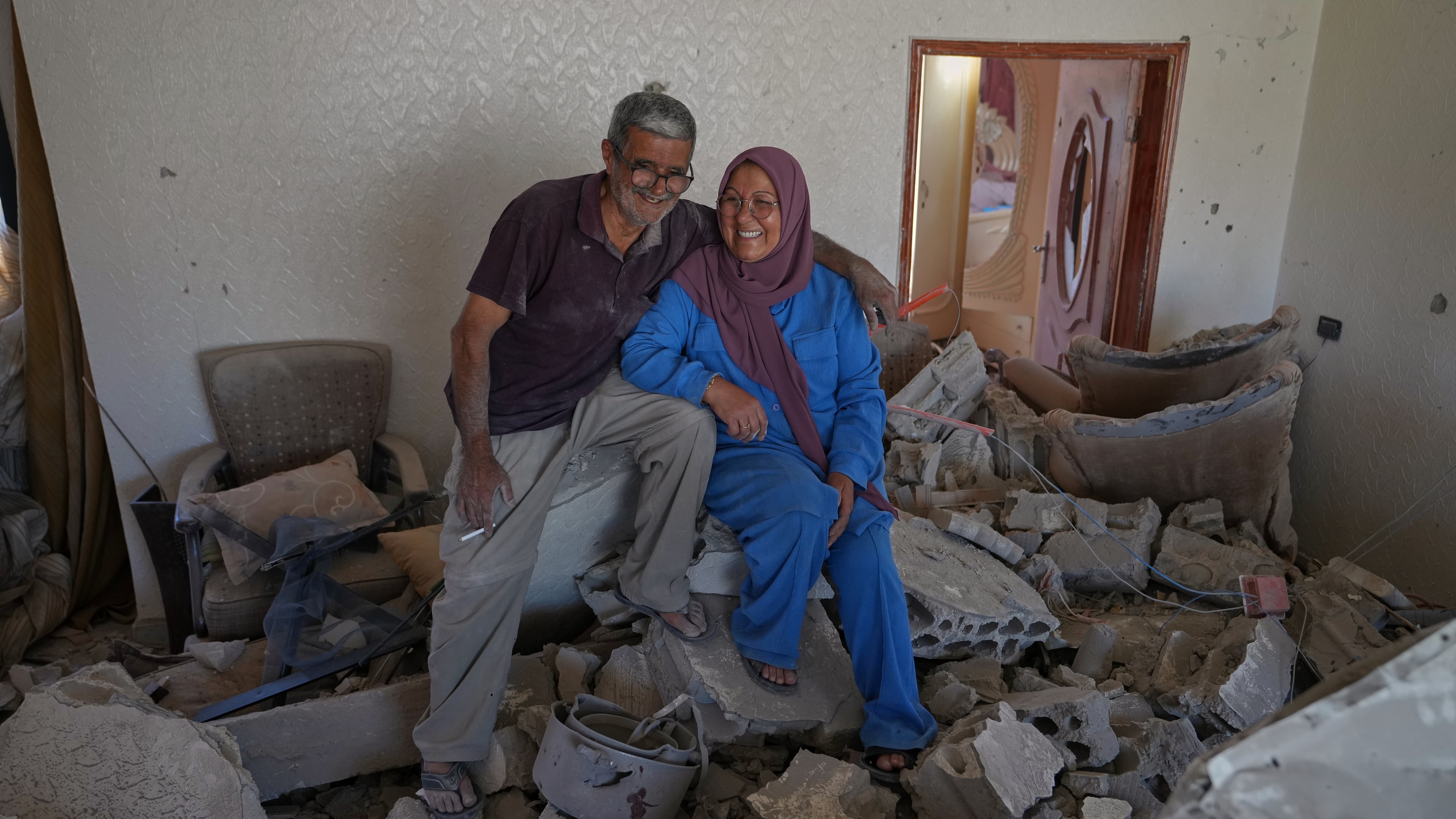 Mahasen Faqih and her husband, Mohammed Sobeih, smile as they sit amid the rubble of their home after returning to it following the Israeli military operation in Zawtar al-Gharbieh, Lebanon, Tuesday, July 28, 2026. (AP Photo/Hassan Ammar)