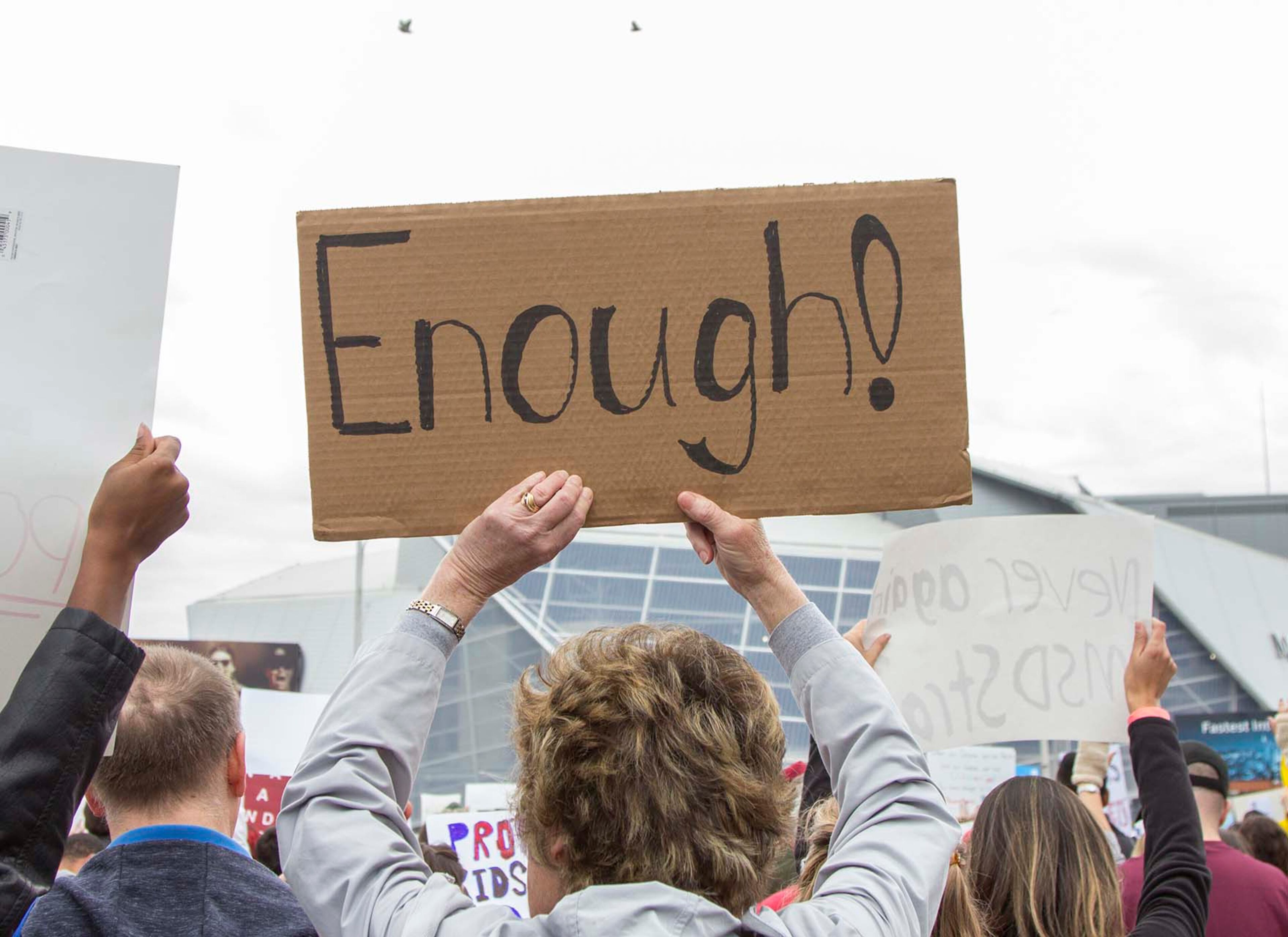 A woman holds up a sign reading "Enough!" during the March for our Lives event in Atlanta, Georgia, on Saturday, March 24, 2018. (REANN HUBER/REANN.HUBER@AJC.COM)