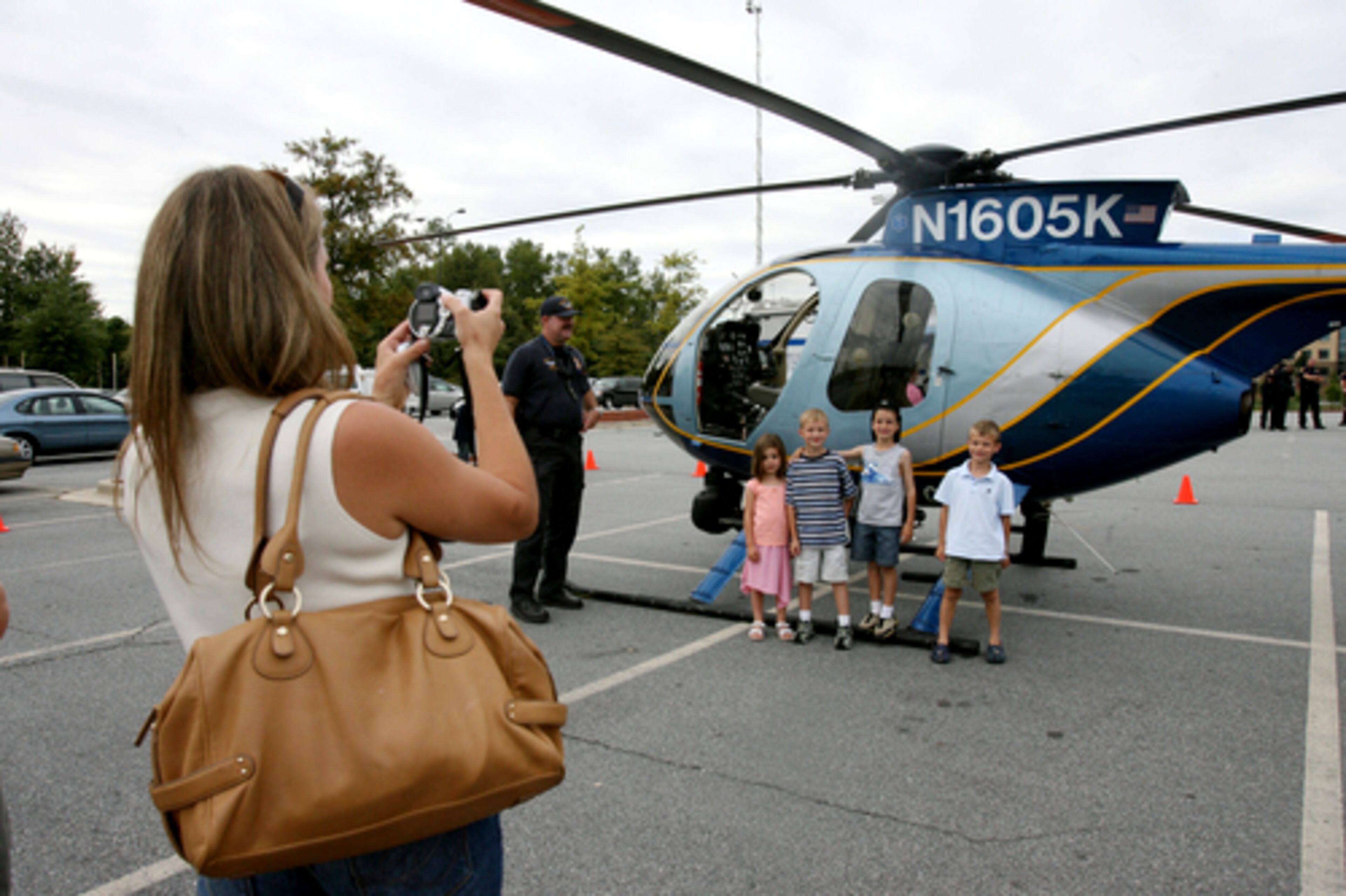 Lisa Angove (back to camera), of Berkeley Lake, captures a photo of (left to right) Allison Sansone, Nicholas Angove, Cameron Sansone and Matthew Angove as they visit the COPS Festival.