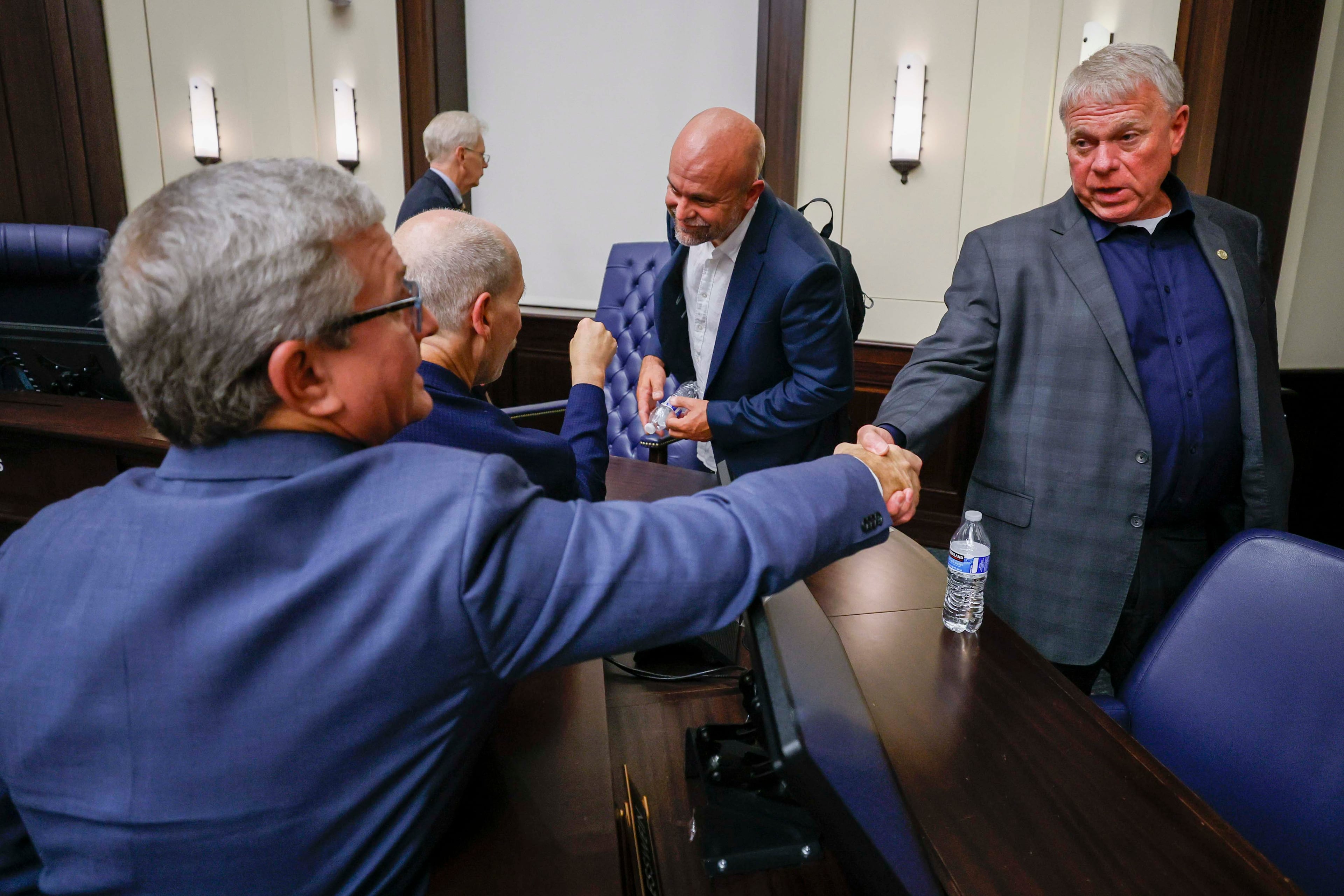 Tim Perry, managing director and chief investment officer at Jamestown, shakes hands with Alpharetta Mayor Jim Gilvin on Tuesday, Aug. 25, 2025, after the City Council votes 4-3 to rezone Jamestown’s mall redevelopment, which is vying to attract an NHL franchise. (Miguel Martinez/AJC)