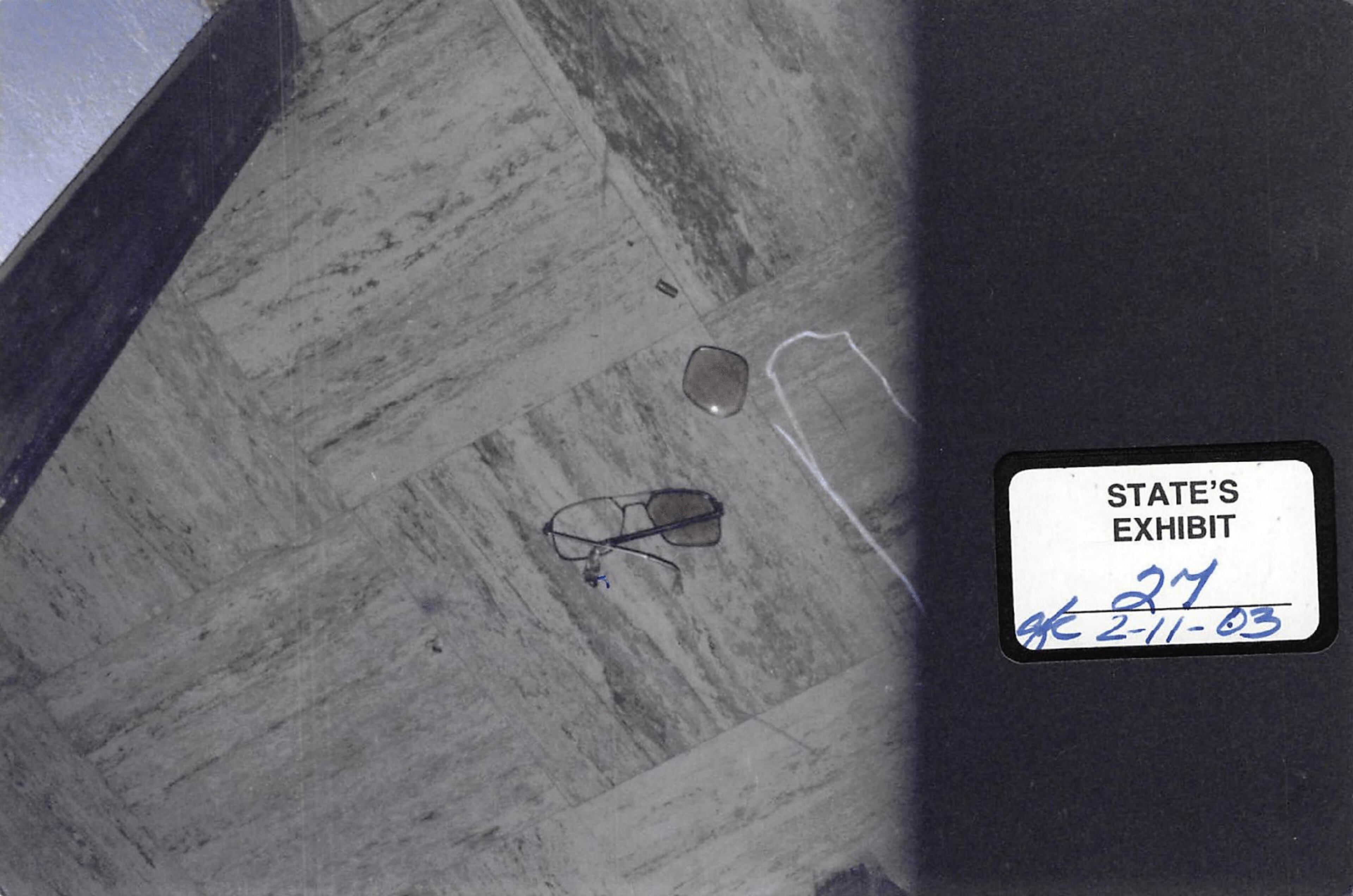A pair of broken glasses are shown where they were found at the crime scene--inches from the body of Harold Swain in the vestibule.