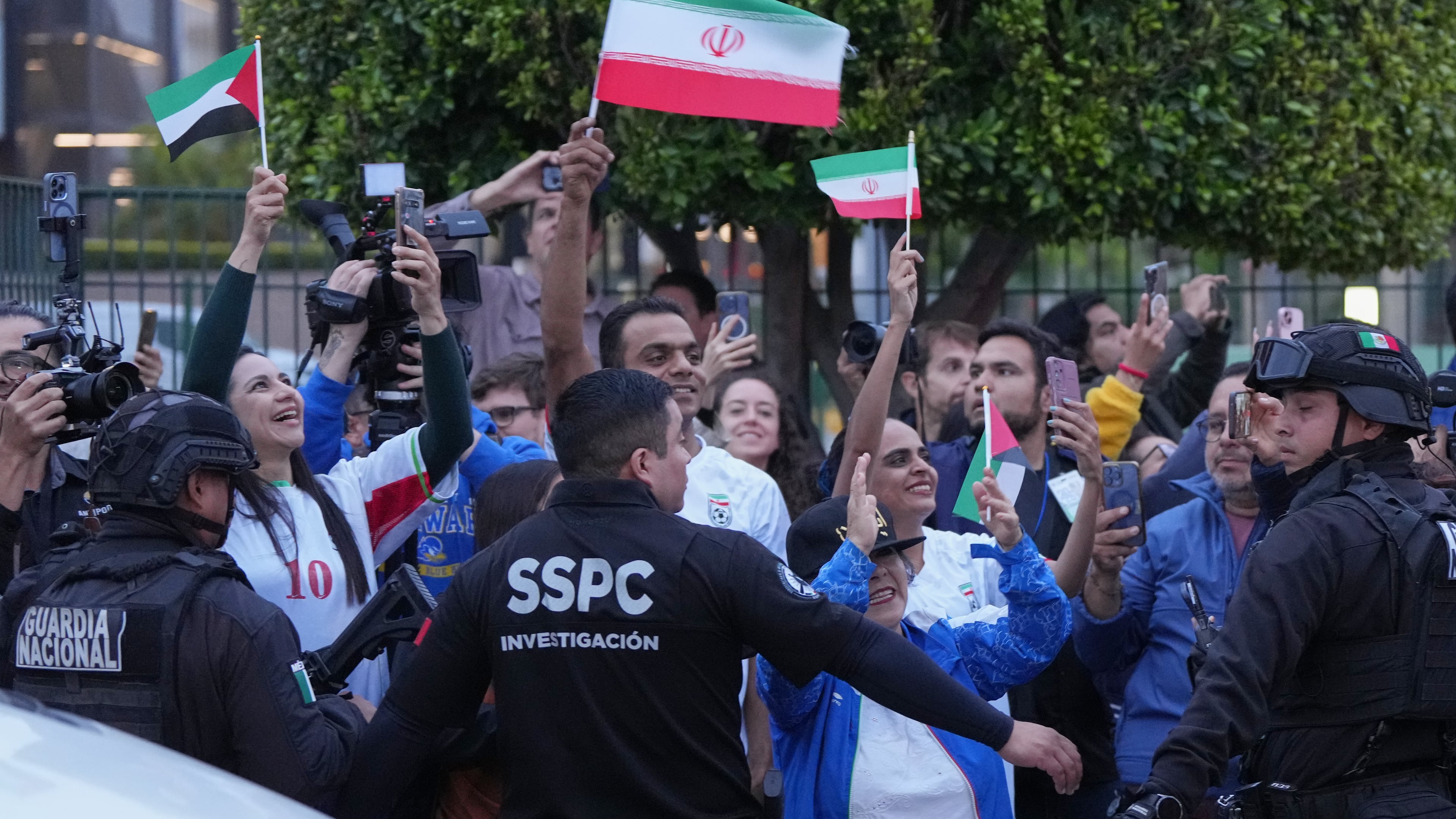 Fans for team Iran wave as players arrive for the World Cup soccer tournament in Tijuana, Mexico, Sunday, June 7, 2026. (AP Photo/Gregory Bull)