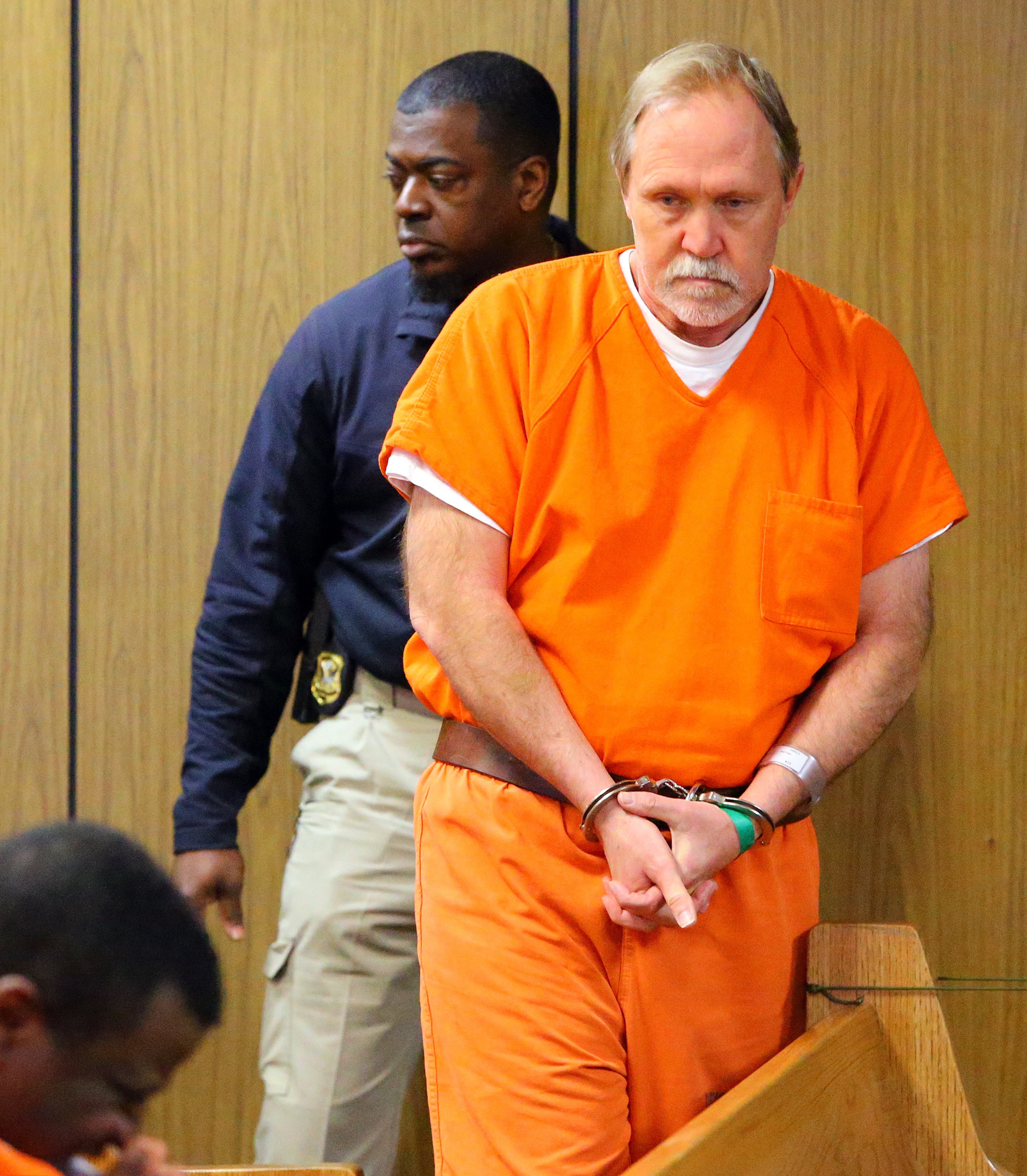 John McGill, principal of Mt. Carmel Elementary School in Douglas County, is brought into the courtroom for his first appearance hearing at DeKalb County Magistrate Court for a felony offense of electronic pornography and attempting to have sex with a minor on Tuesday, March 4, 2014, in Decatur.