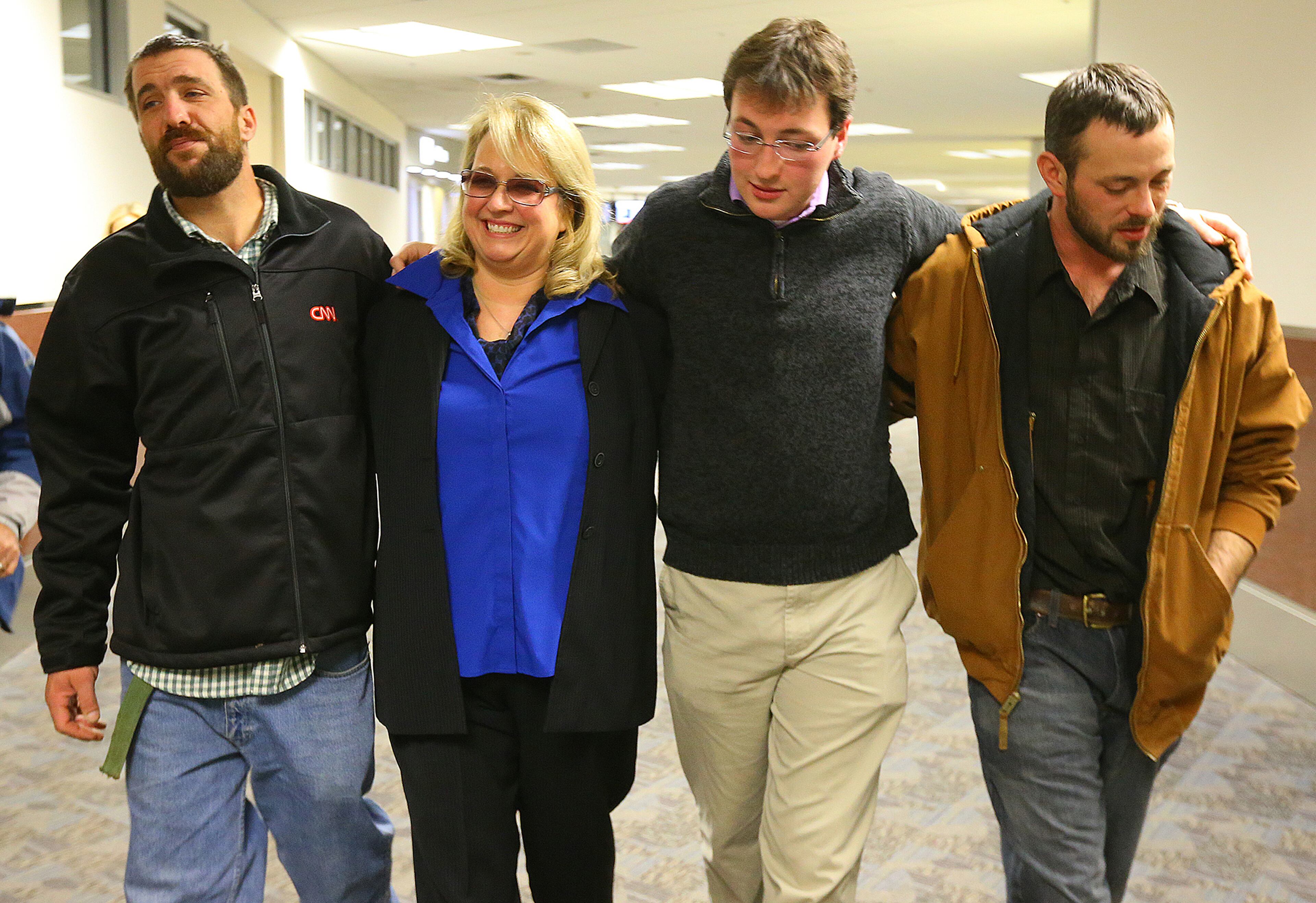 112813 ATLANTA: Reunited with his family on Thanksgiving, Joel Hartman (from left), the homeless man who returned a woman's wallet he found digging through trash hoping to find someone's leftover meal, leaves Hartsfield Jackson Atlanta Airport with his stepmother Deanna Rodecki, and brothers Andrew Rodecki and Erick Hordos for the Omni Hotel at CNN Center and a Thanksgiving Day meal on Thursday, Nov. 28, 2013, in Atlanta. CURTIS COMPTON /staff CCOMPTON@AJC.COM