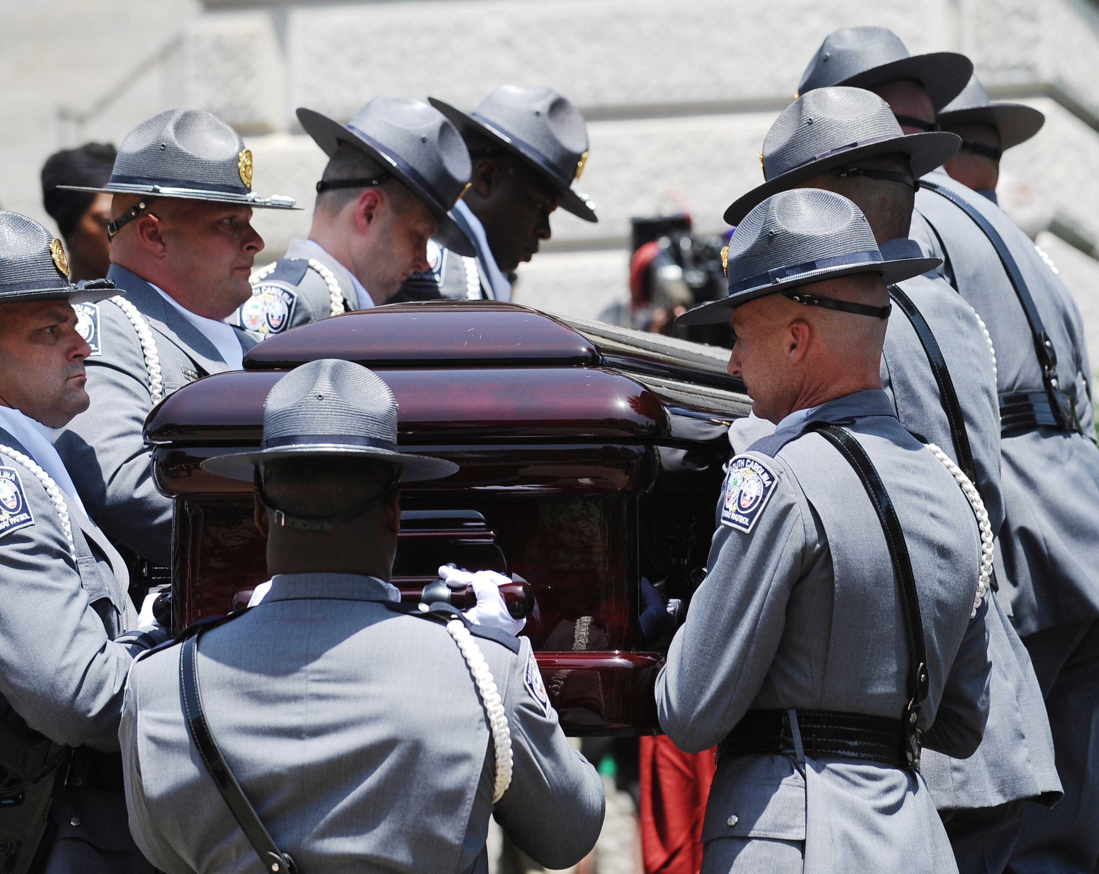 A South Carolina Highway Patrol honor guard carries Sen. Clementa Pinckney's casket to the Statehouse, Wednesday, June 24, 2015, in Columbia, S.C. Pinckney's open coffin was being put on display under the dome where he served the state for nearly 20 years. Pinckney was one of those killed in a mass shooting at the Emanuel AME Church in Charleston. (AP Photo/Rainier Ehrhardt)