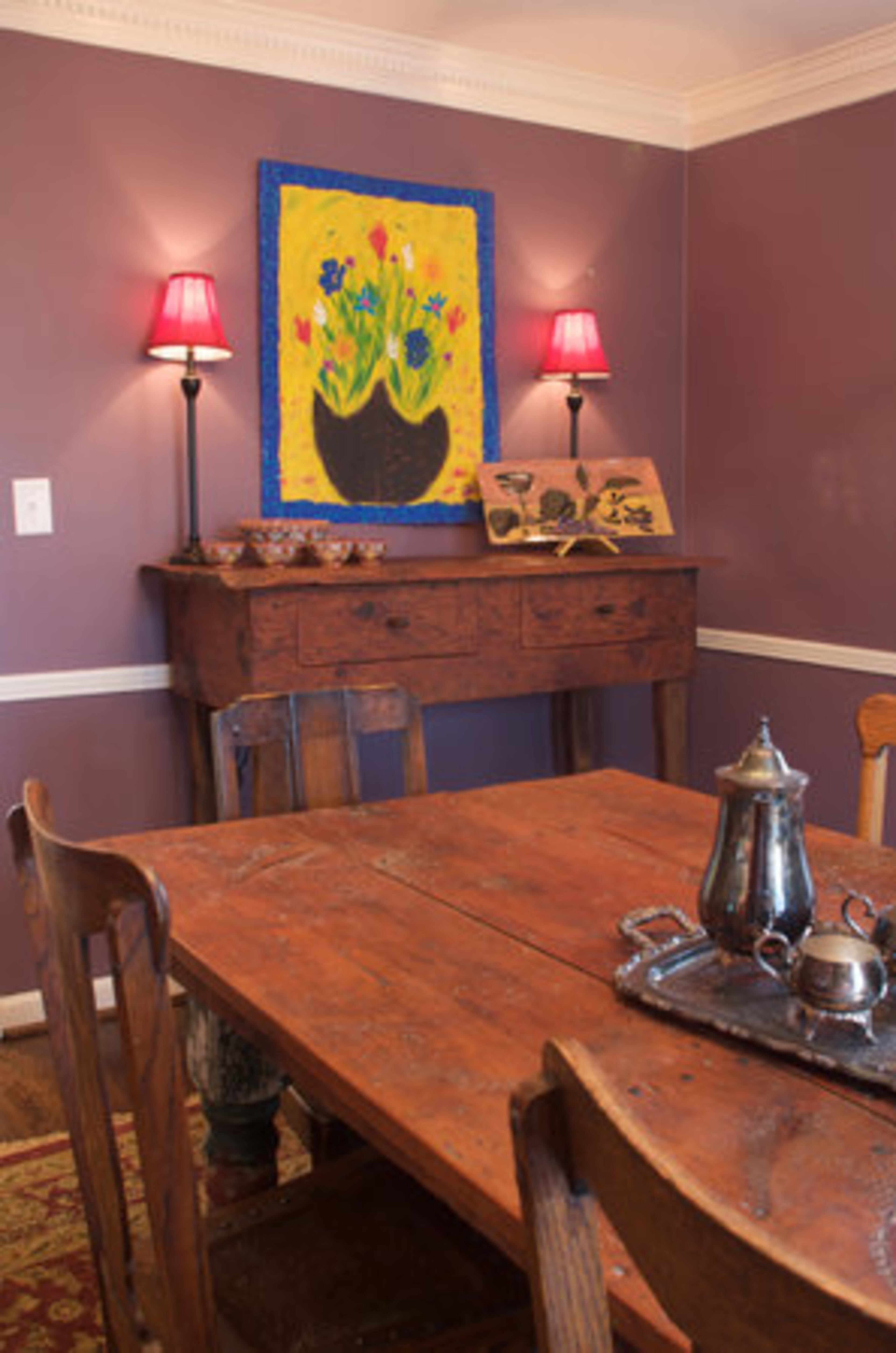The hunt board and dining room table were designed by Dannette Sperry, co-owner of Primitive Folks, a folk art studio in Maysville. "The hunt boards were once used by hunters who were dirty from being on their horses all day or from walking in the fields and didn't want to go inside their homes and sit at the formal table," says Murray Shevlin. "They stood over the hunt board and ate their meal before skinning and cleaning their game."