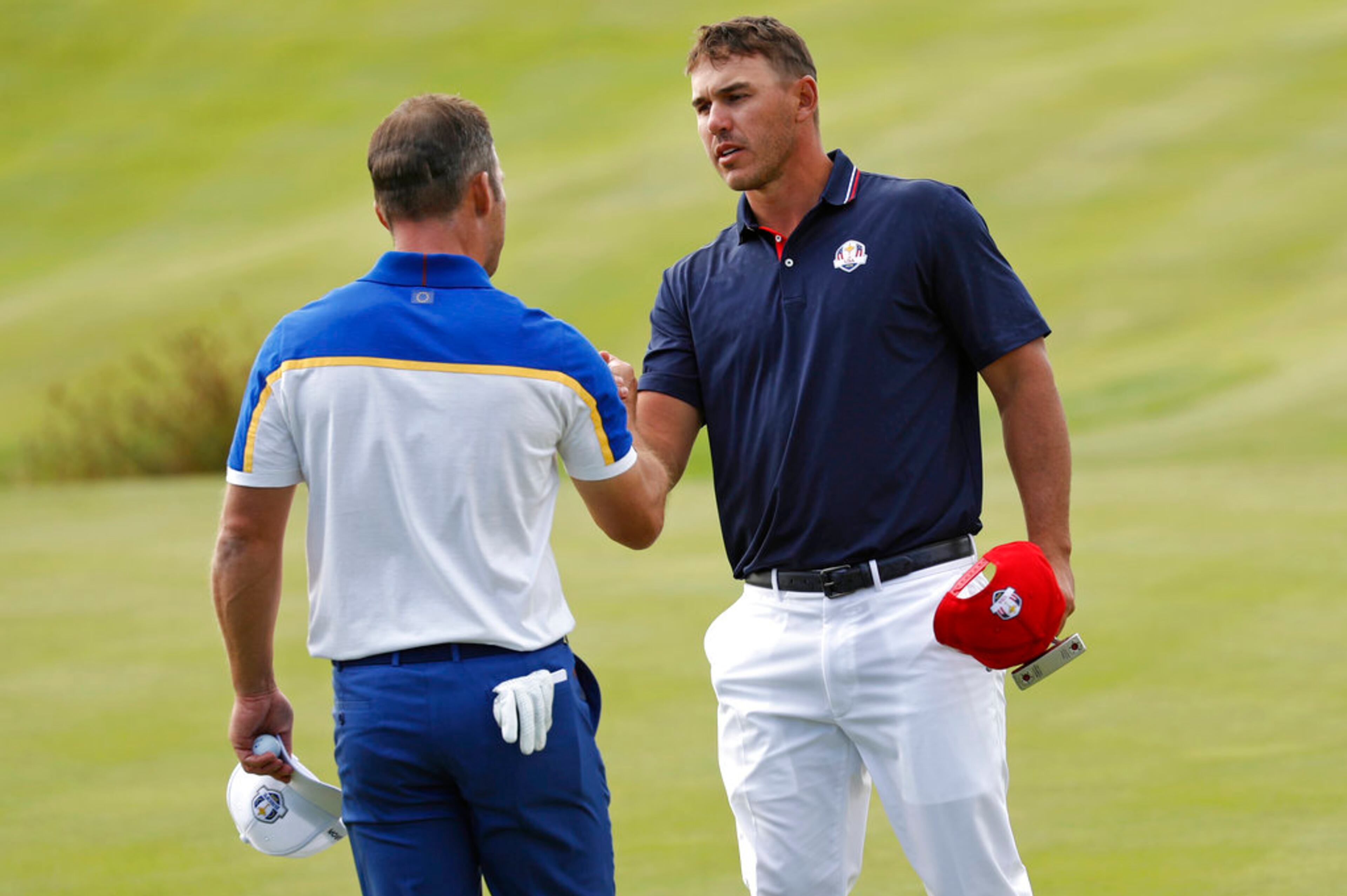 Europe's Paul Casey, left, and Brooks Koepka of the US shake hands at the end of their singles match on the final day of the 42nd Ryder Cup at Le Golf National in Saint-Quentin-en-Yvelines, outside Paris, France, Sunday, Sept. 30, 2018. They halved their match. (AP Photo/Laurent Cipriani)