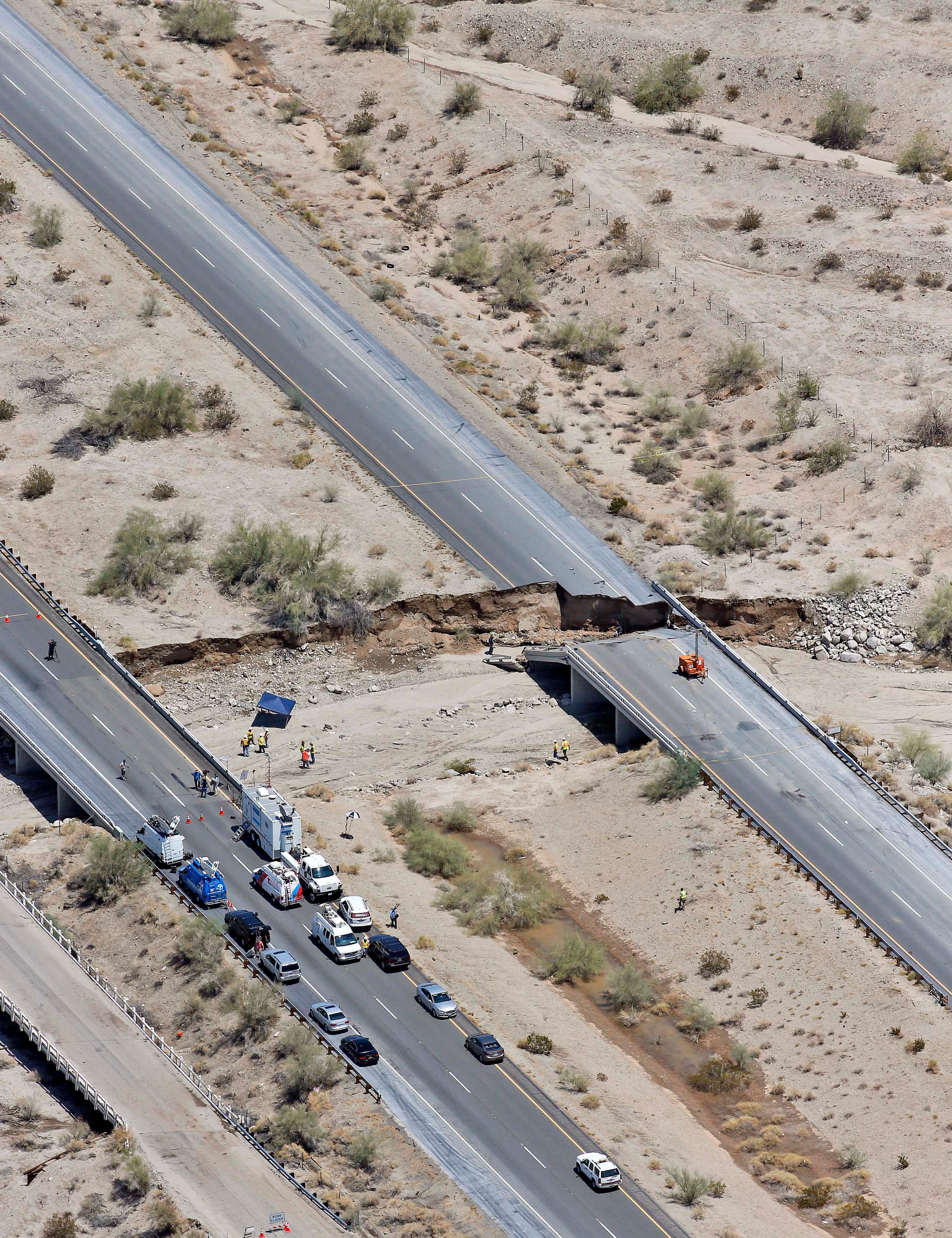 A collapsed elevated section of Interstate 10 is seen from the air, Monday, July 20, 2015, in Desert Center, Calif. All traffic along one of the major highways connecting California and Arizona was blocked indefinitely when the bridge over a desert wash collapsed during a major storm, and the roadway in the opposite direction sustained severe damage. (AP Photo/Matt York)