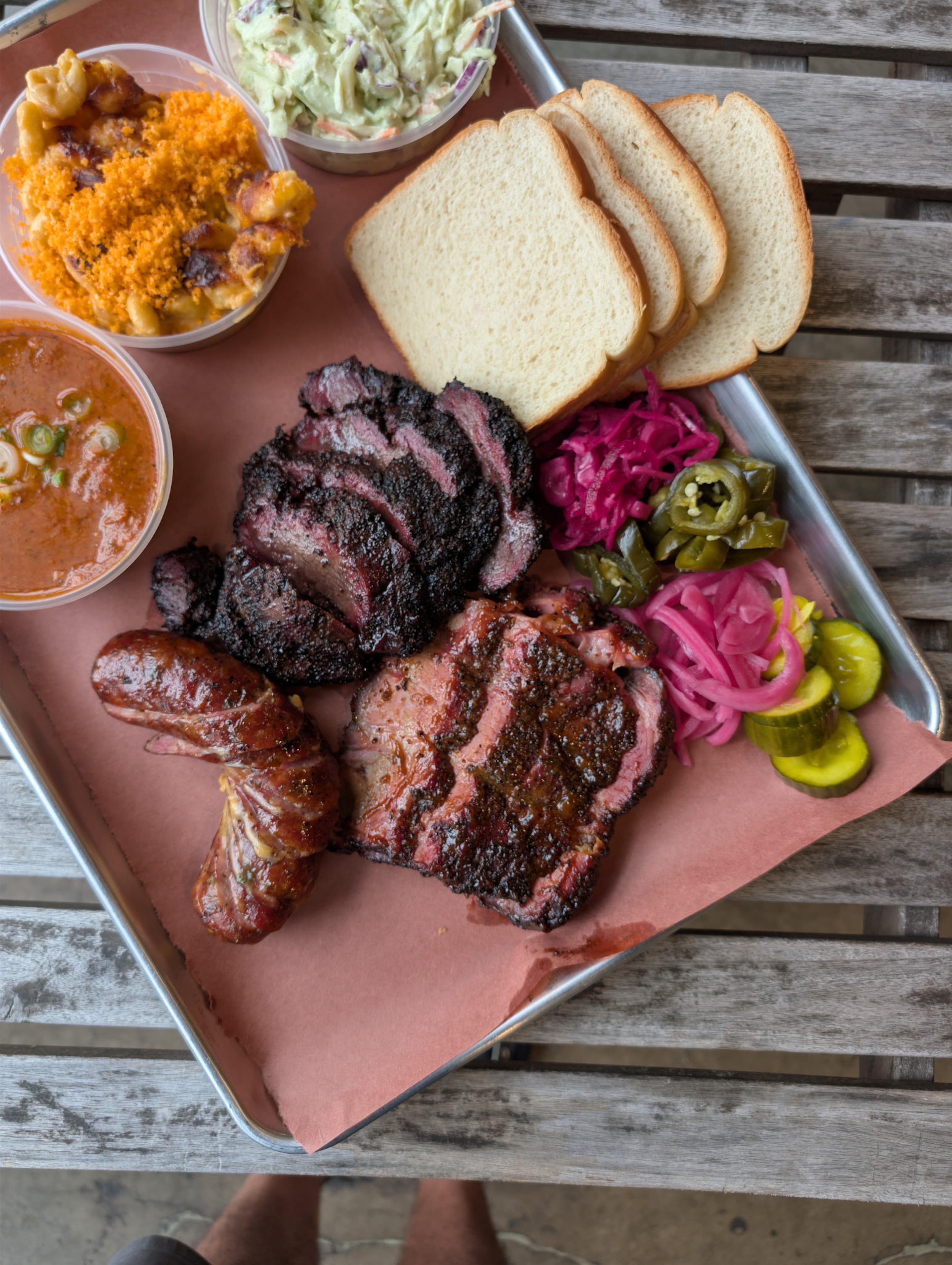 The Misfitsss deep cut: (clockwise from top) green chile ranch slaw, white bread, house pickles, peach sweet tea-glazed pork steak, beef cheek, housemade black pepper garlic sausage, Thai hash and rice, and macaroni and cheese with Cheetos dust. (Courtesy of Ted Golden)