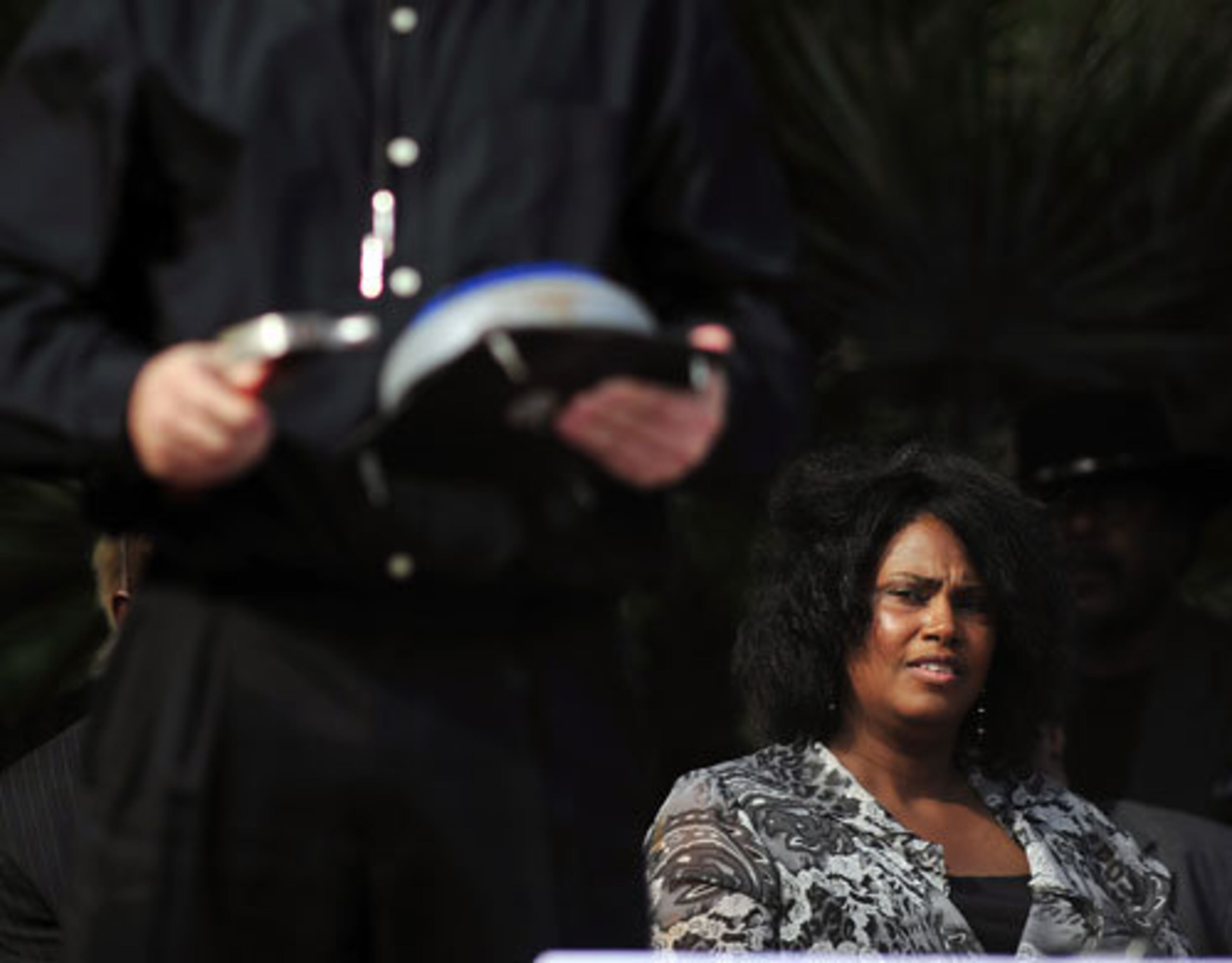 Joe Frazier's niece Dannette Frazier listens to a local trainer ring a bell during a memorial service for her uncle the former heavyweight champion at the Waterfront Park.