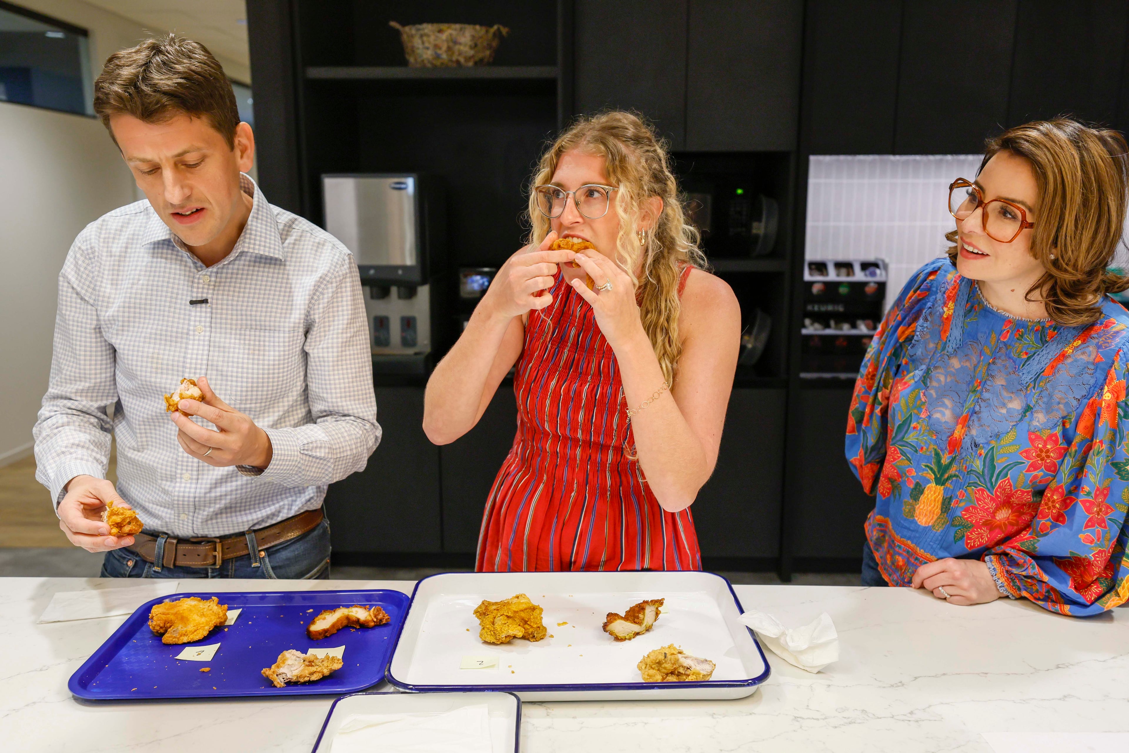 AJC Food & Dining Senior Editor Monti Carlo watches Lifestyle Reporter Olivia Wakim and Sr. Enterprise Reporter Thomas Lake sample fried chicken at a contest on Tuesday, Aug. 25, 2026, at the AJC office in Midtown. The event aims to find Atlanta’s top fried chicken. (Miguel Martinez/AJC)