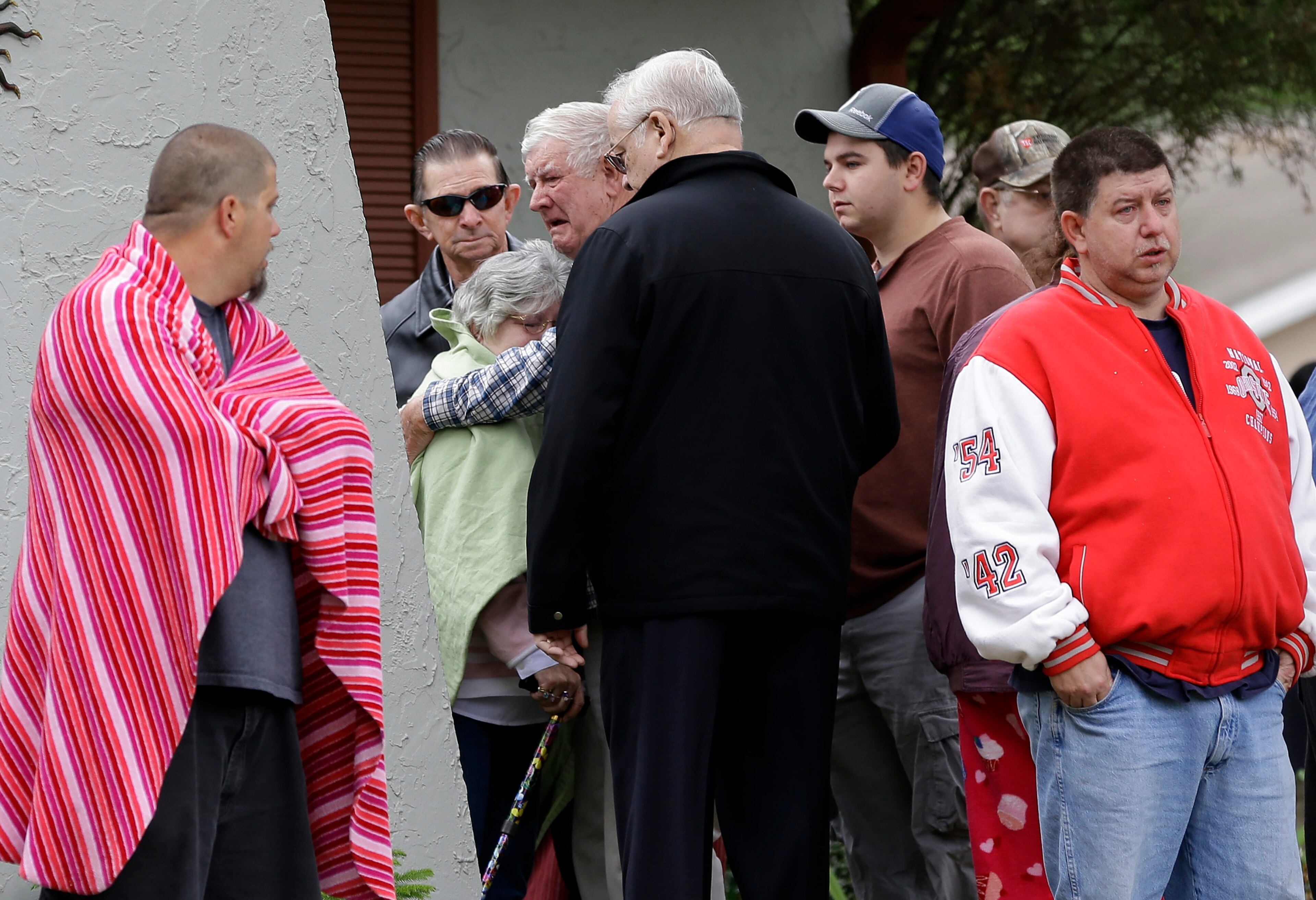 Family members console each other near the home.