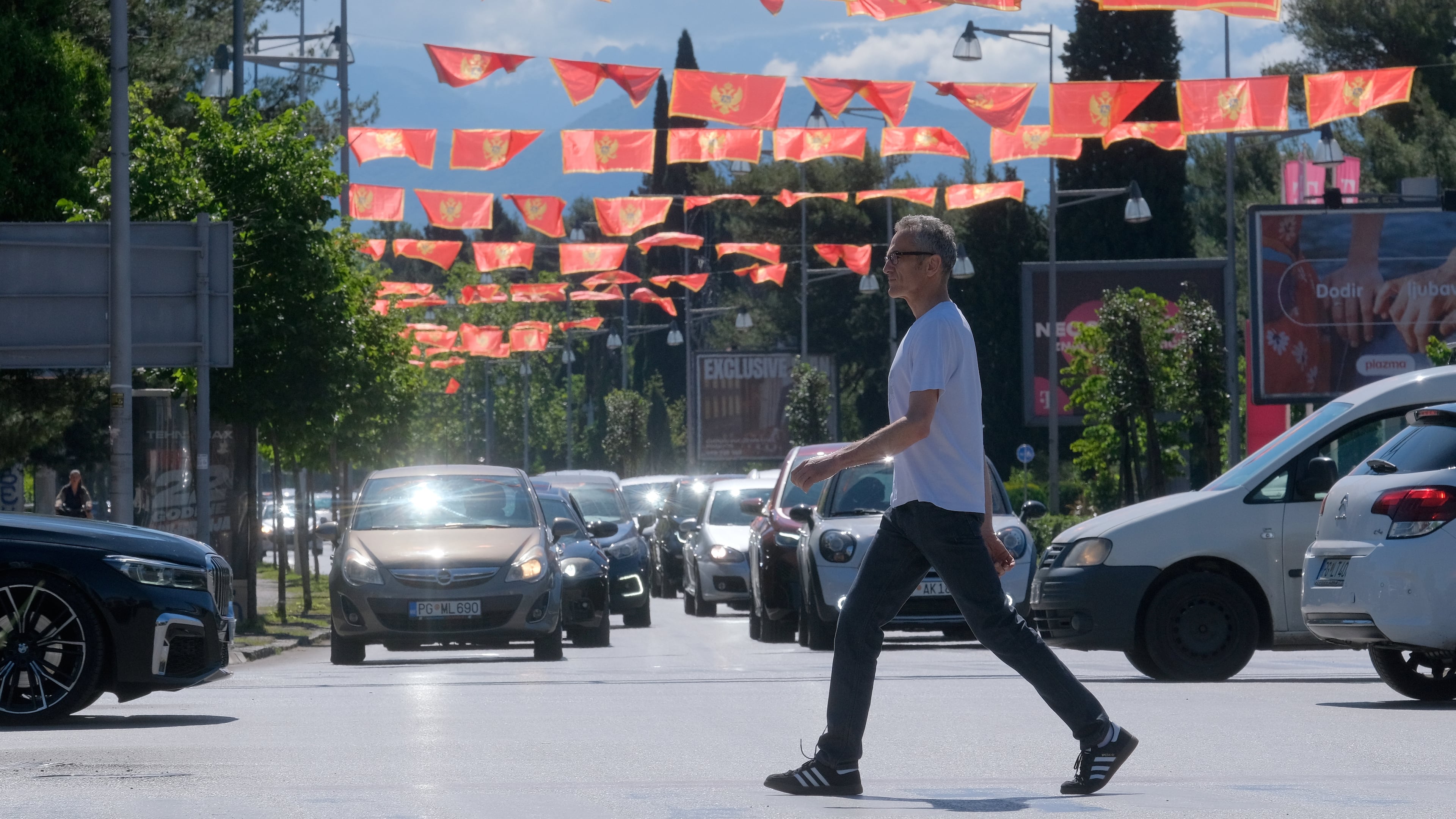 A man walks on a street decorated with national flags in Montenegro's capital Podgorica, Monday, May 18, 2026. (AP Photo/Risto Bozovic)
