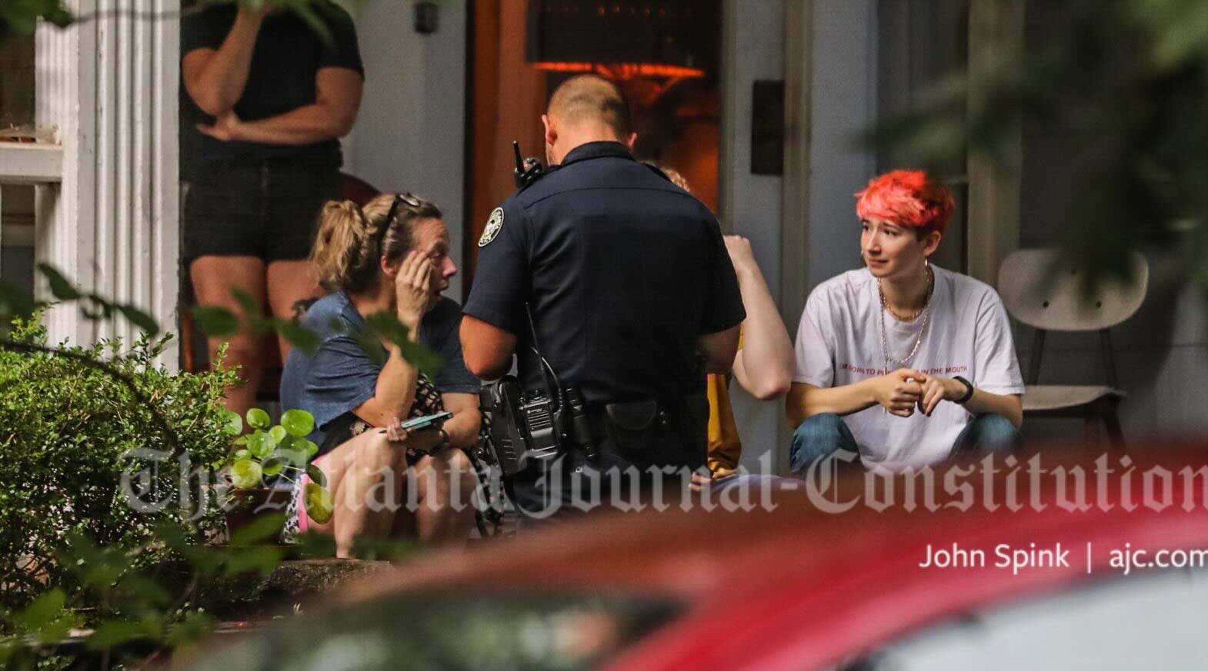 A firefighter speaks with residents of the Candler Park home crushed by a tree Tuesday.