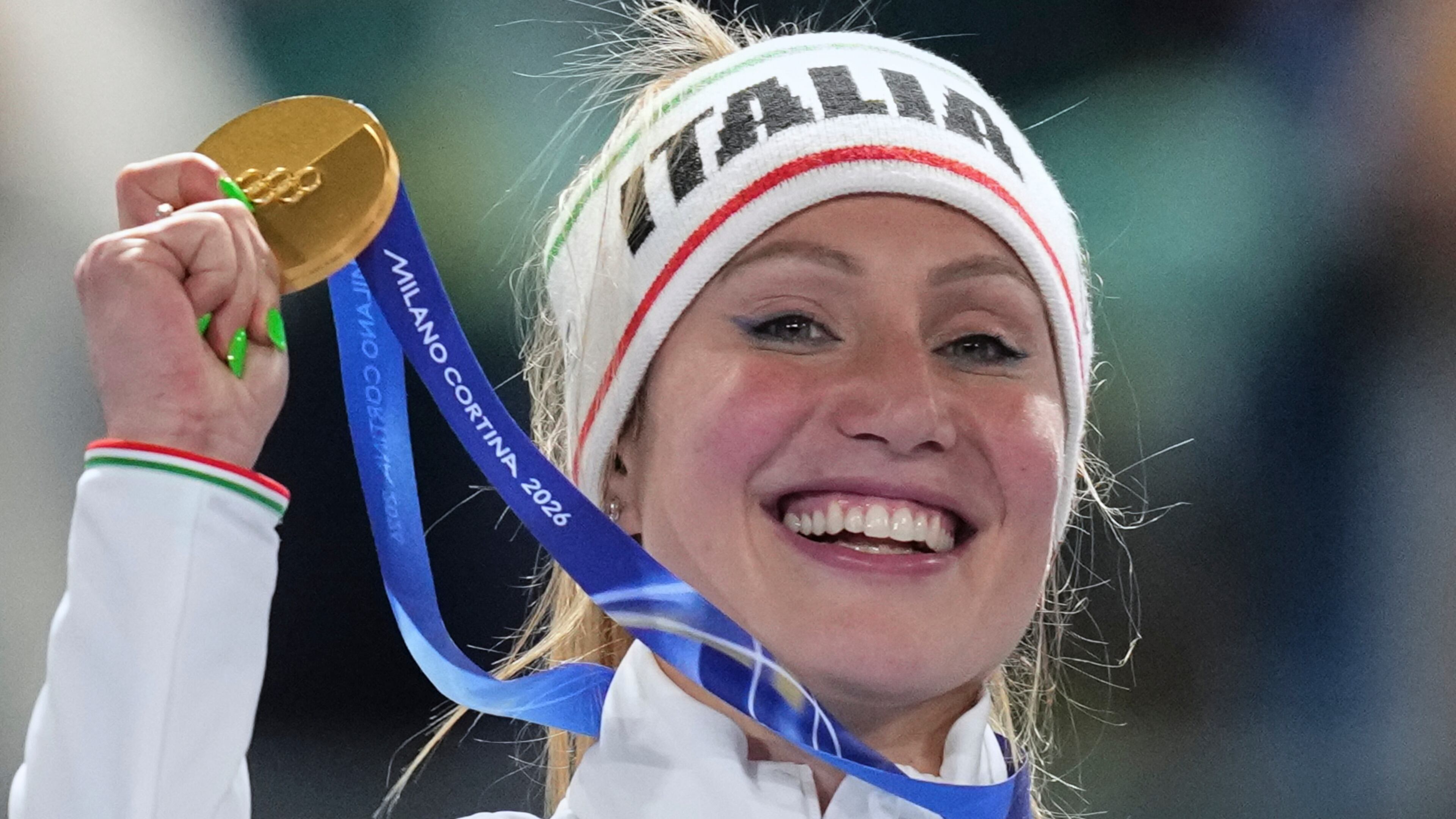 Francesca Lollobrigida of Italy celebrates with her gold medal on the podium of the women's 3,000 meters speedskating race at the 2026 Winter Olympics, in Milan, Italy, Saturday, Feb. 7, 2026. (AP Photo/Christophe Ena)